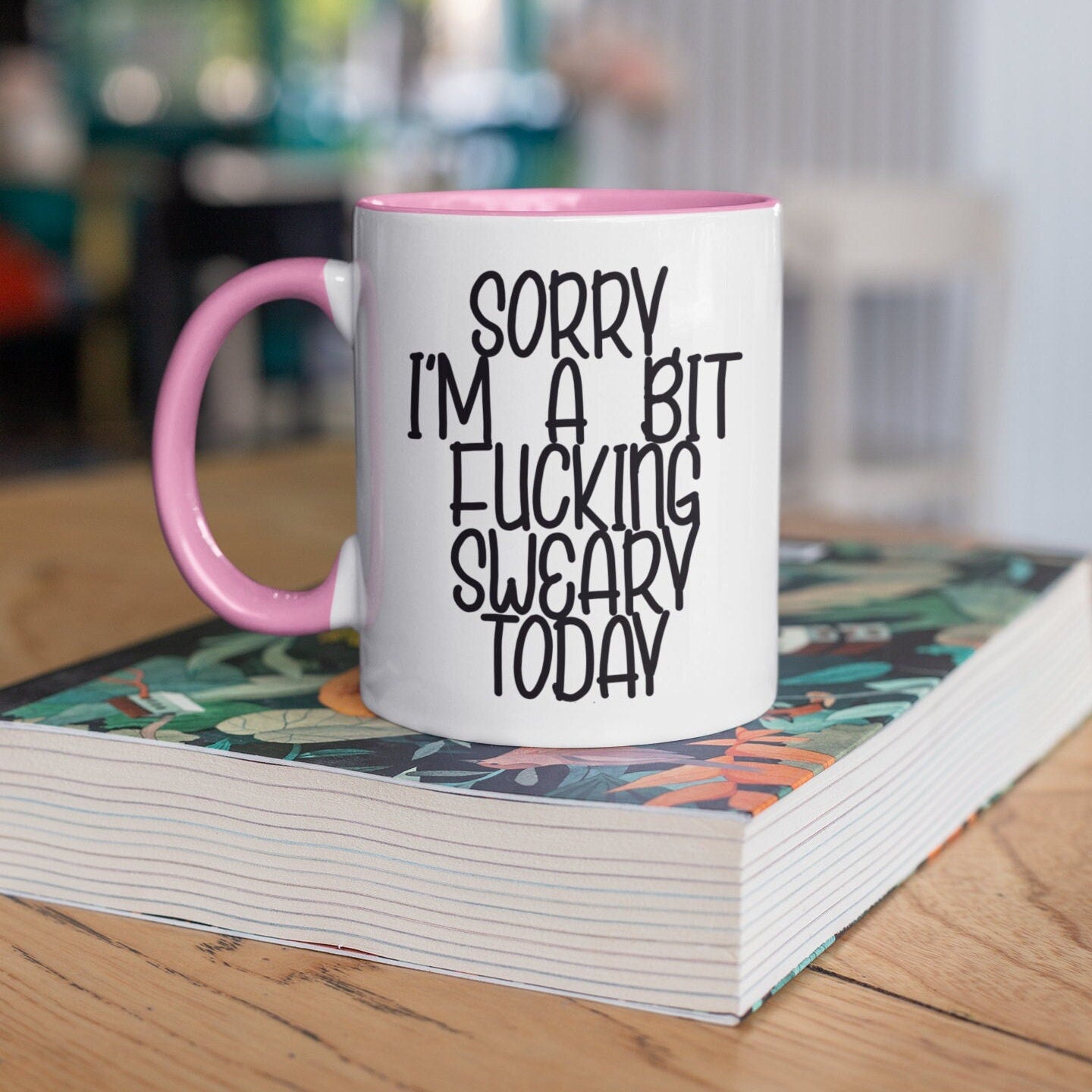A white ceramic mug with a black handle, featuring the funny quote 'sorry i'm a bit fucking swearing today'. Printed in black ink.