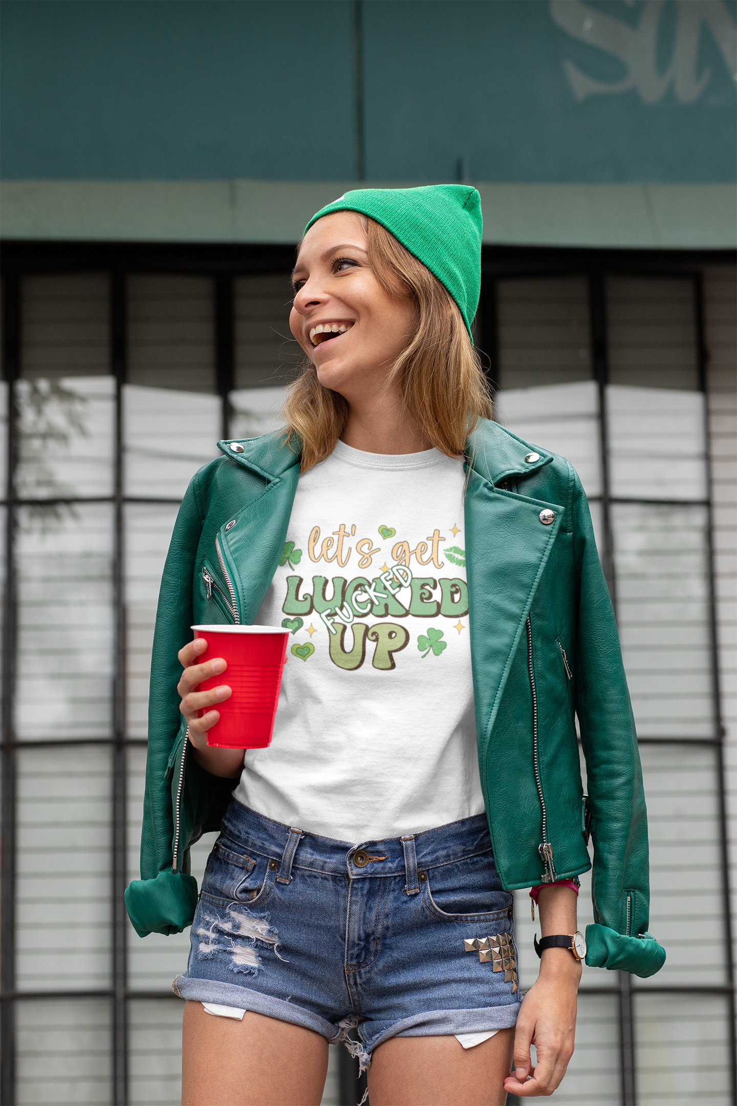 White tshirt with a St Patricks day logo to the front which reads 'let's get lucked up' with the word 'fucked' over the top of the word luck. In bold green colours with clovers surrounding the design.