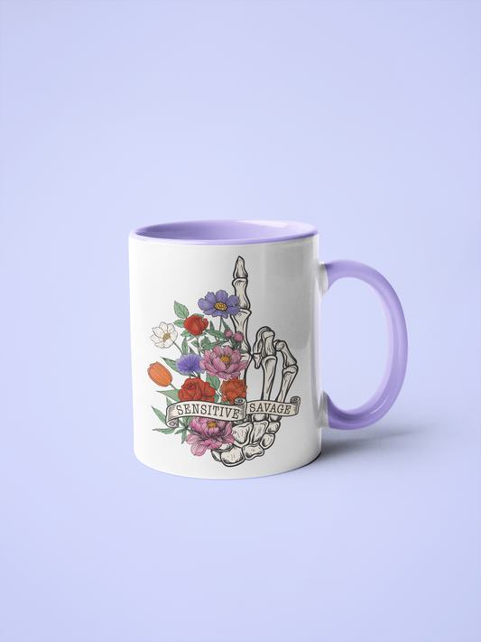 11oz white mug with a skull hand giving the middle finger and the quote 'sensitive, savage' with flowers