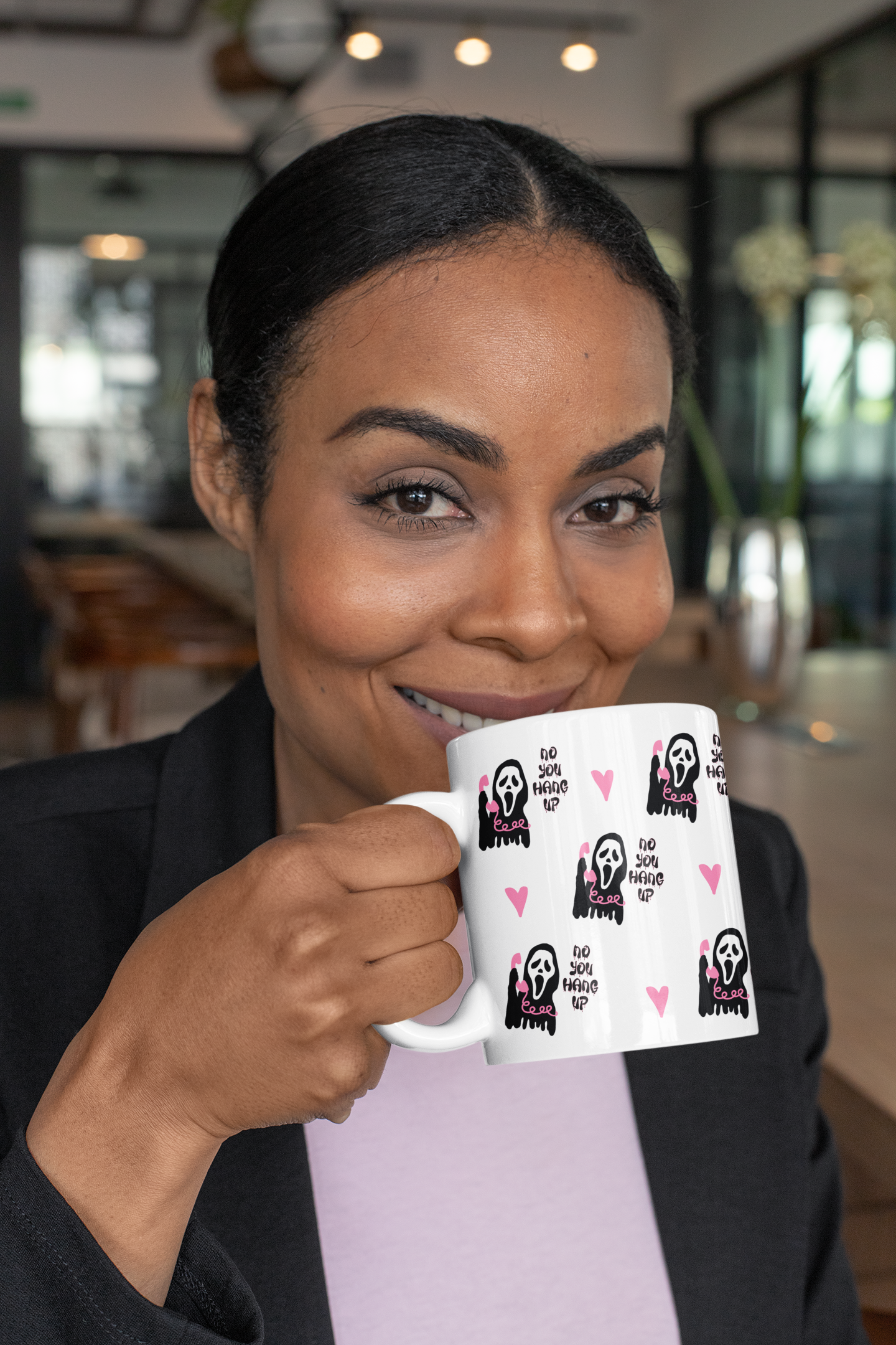 A mug featuring a design taken from the scream film, with the famous mask and quote 'no you hang up'. All in pretty pink and black colours.