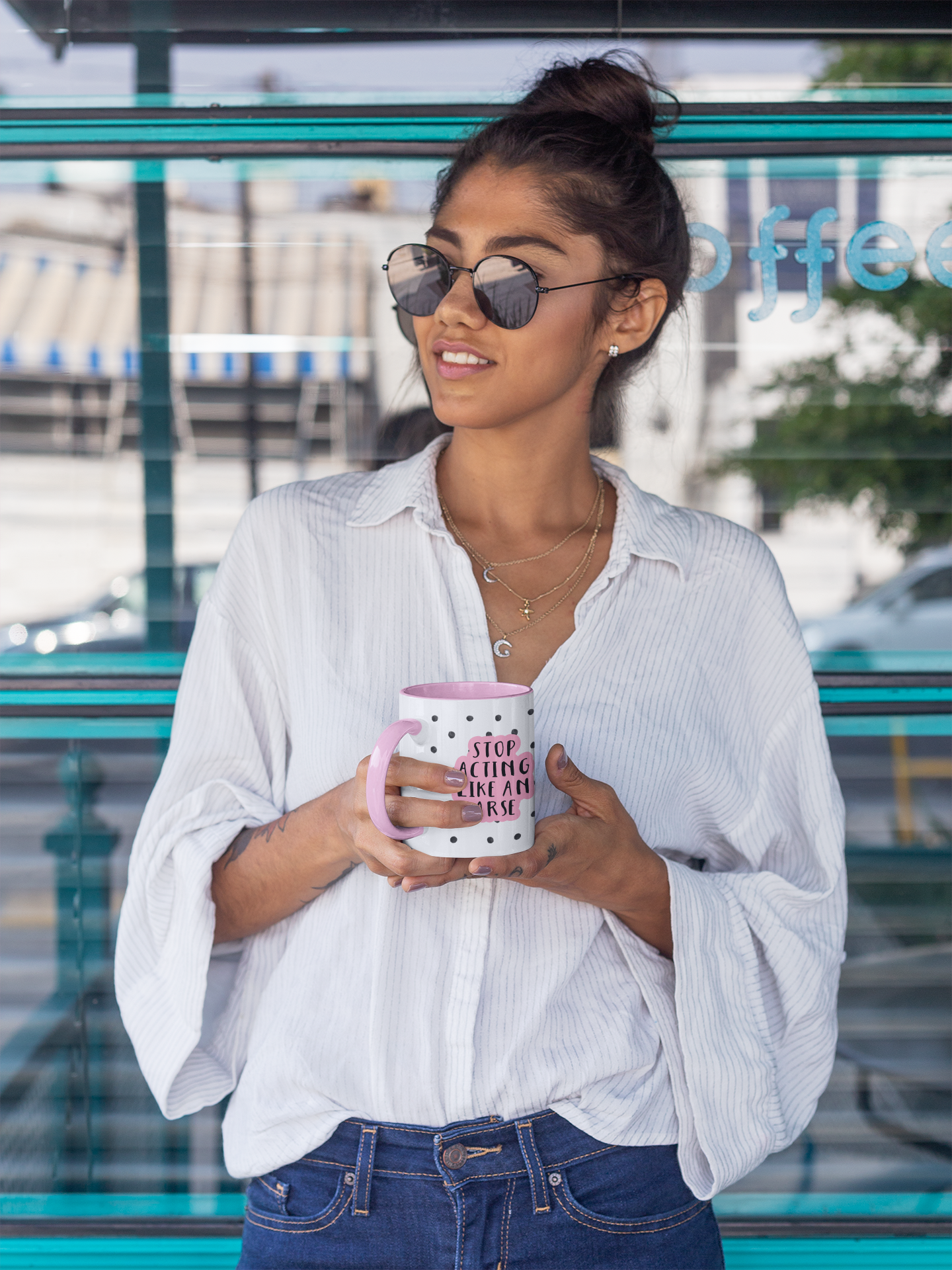 White ceramic mug with a black water-coloured spotty background & the quote 'stop acting like an arse' situated over the top. The wording is printed in black with a baby pink outline.