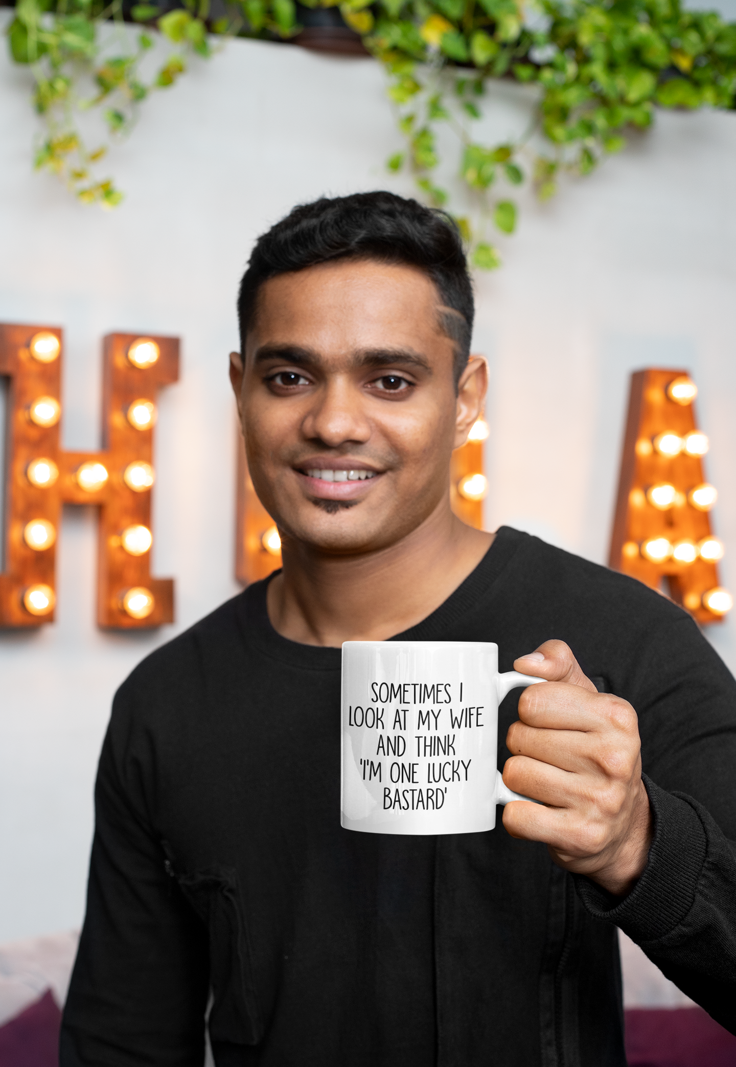Man holding a white mug with a funny quote 'sometimes i look at my wife and think i'm one lucky bastard''. Printed in black ink.