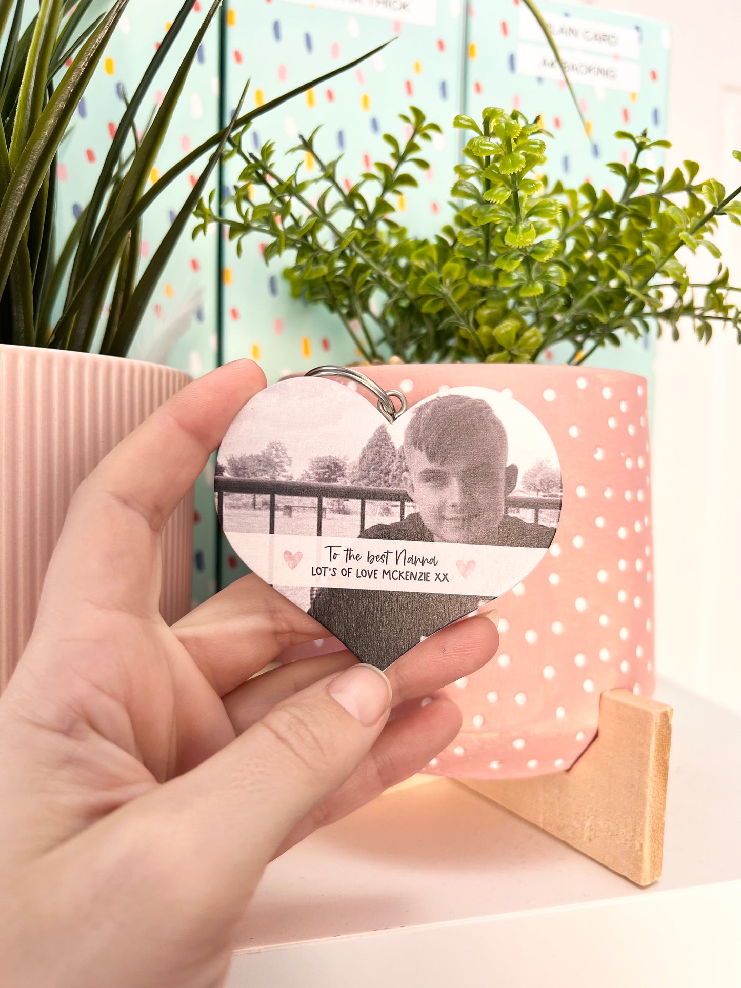 Mdf heart shaped keyring with a pink tassel, featuring a photo of a boy & a custom text underneath in a white banner which reads 'to the best nanna, lot's of love Mckenzie x'.