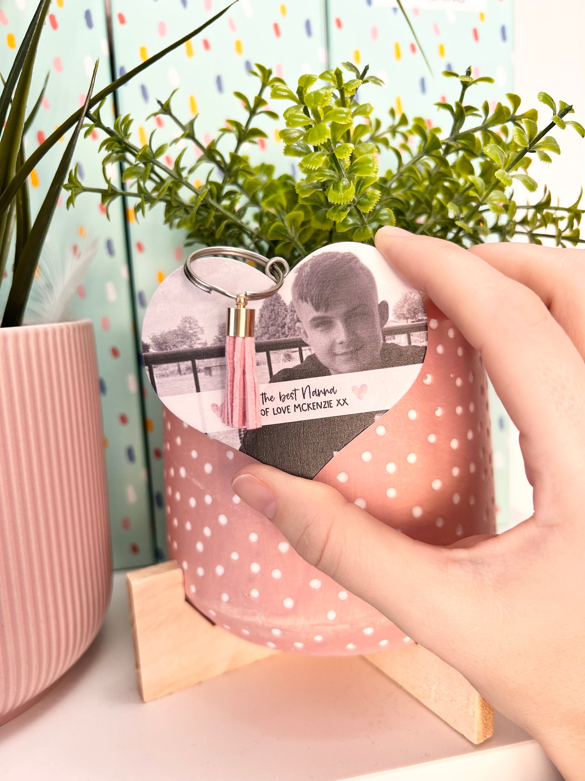 Mdf heart shaped keyring with a pink tassel, featuring a photo of a boy & a custom text underneath in a white banner which reads 'to the best nanna, lot's of love Mckenzie x'.