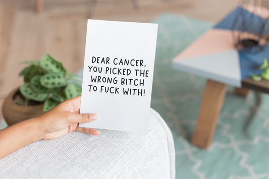 White vertical card with the quote 'dear cancer, you picked the wrong bitch to fuck with' situated in the middle & printed in black.