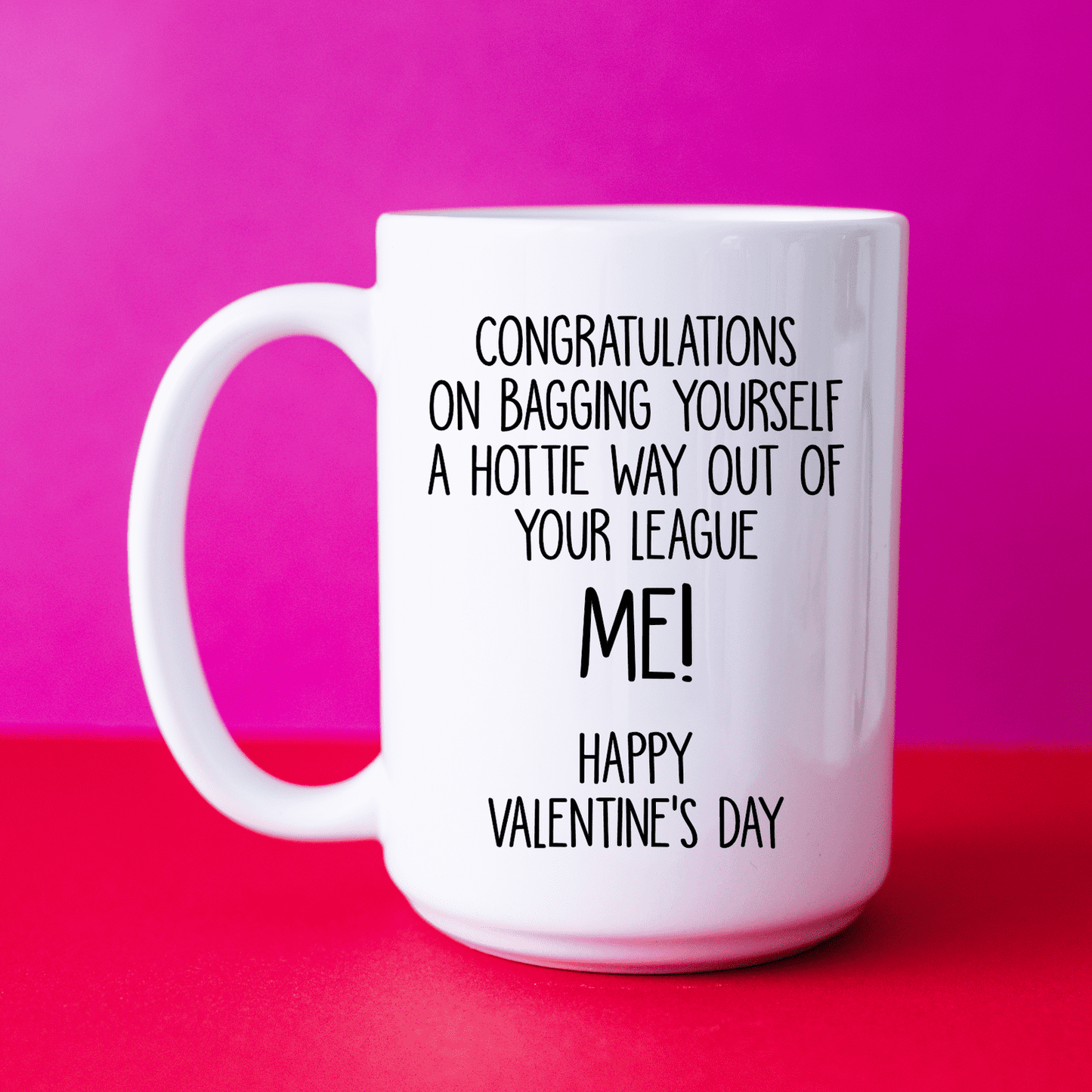A white mug with the funny quote 'congratulations on bagging yourself a hottie way out of your league... Me!' Printed in black ink.