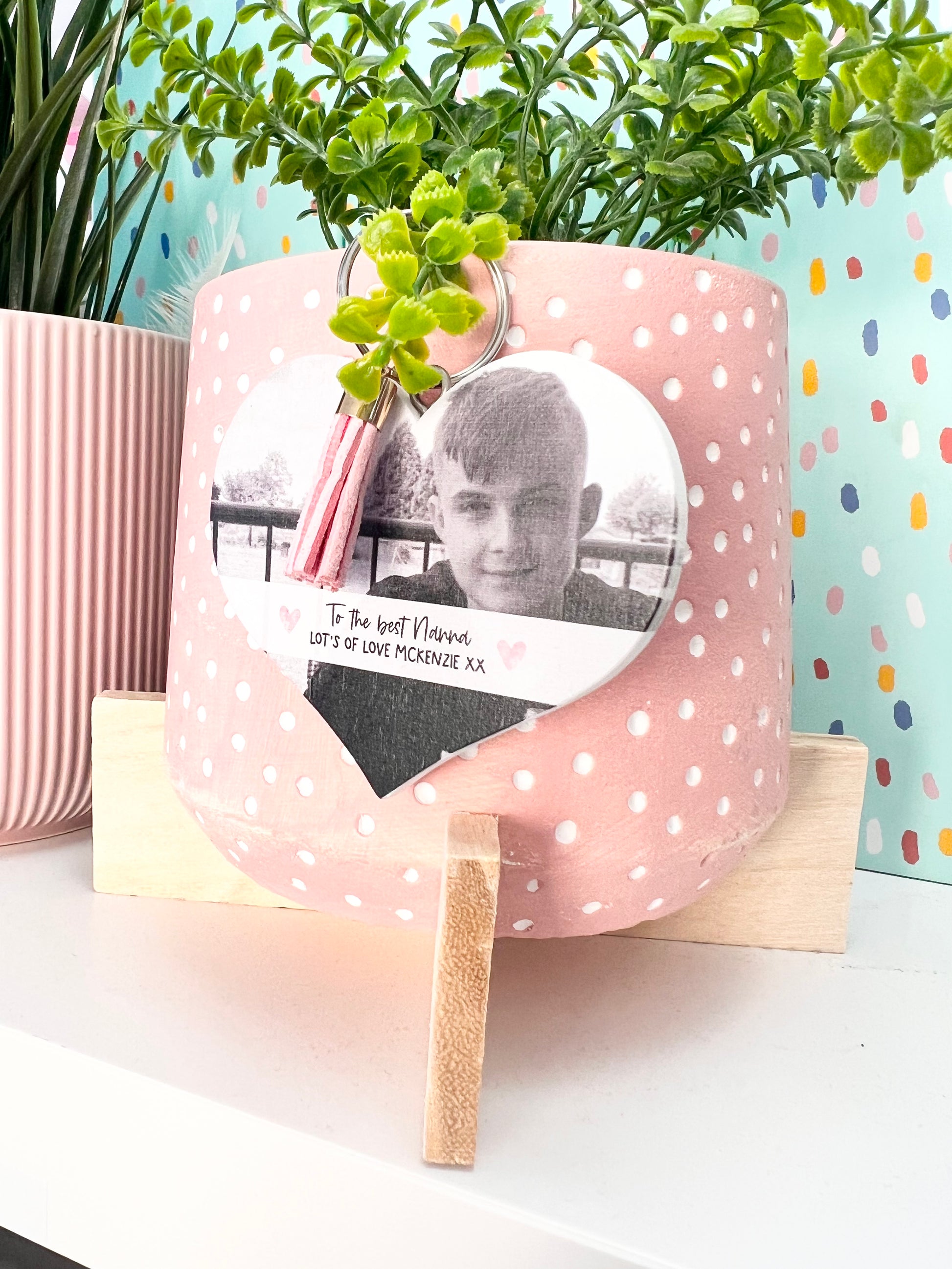 Mdf heart shaped keyring with a pink tassel, featuring a photo of a boy & a custom text underneath in a white banner which reads 'to the best nanna, lot's of love Mckenzie x'.