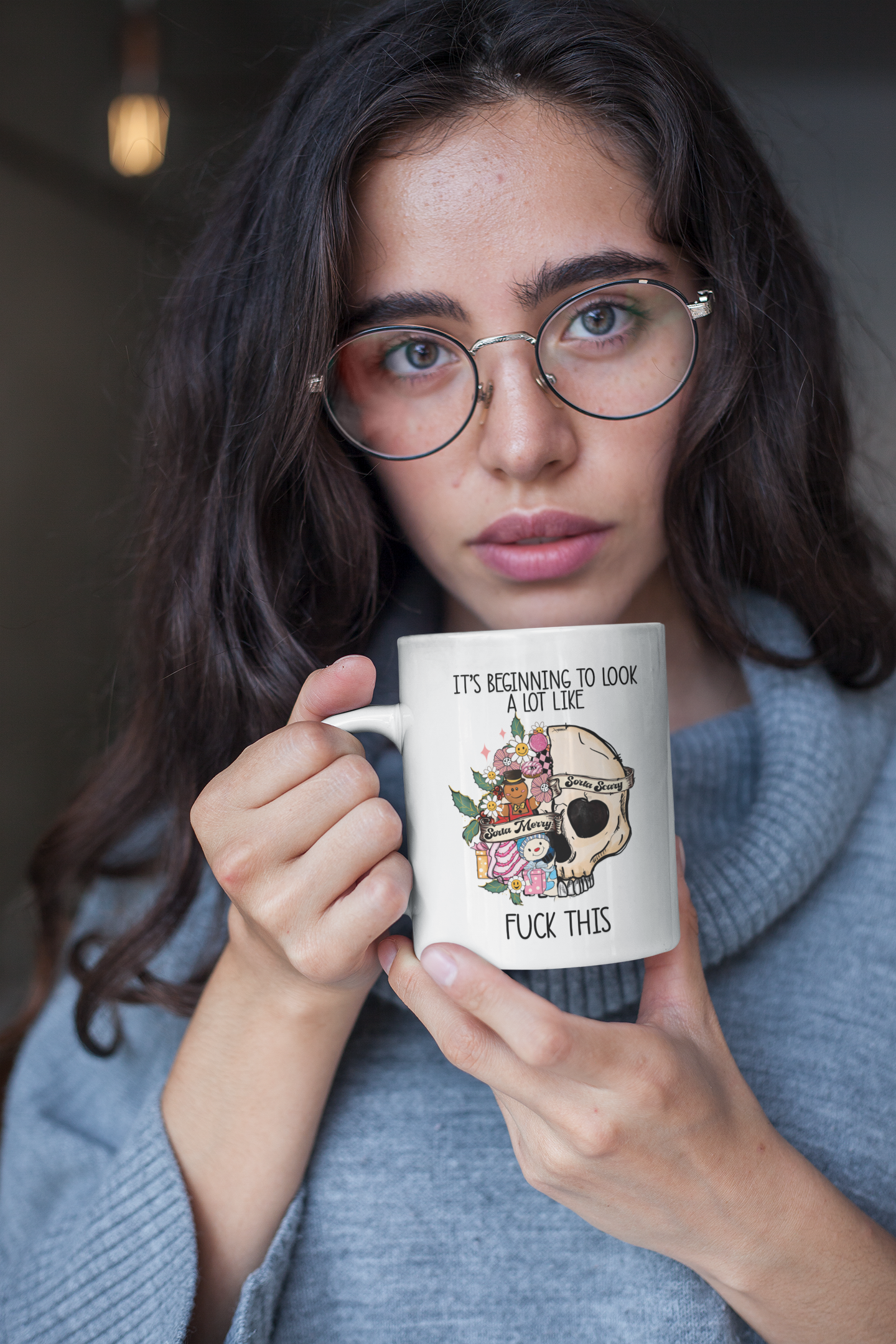White mug with a fun floral christmas skull design with the words it's beginning to look a lot at the top and to the bottom it reads fuck this. Printed in black ink.