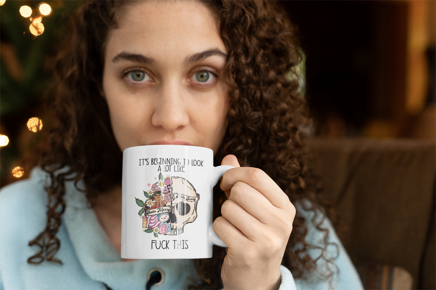 White mug with a fun floral christmas skull design with the words it's beginning to look a lot at the top and to the bottom it reads fuck this. Printed in black ink.