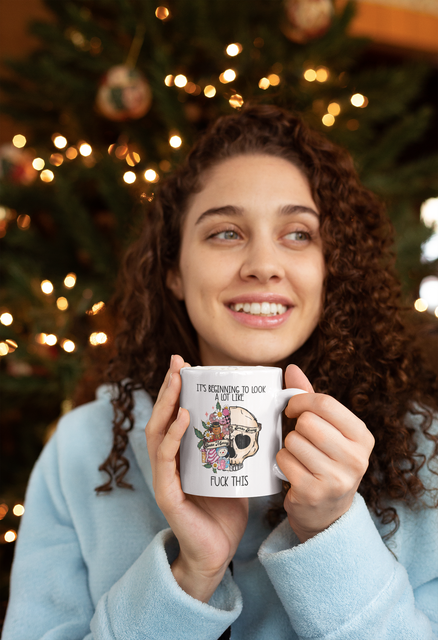 White mug with a fun floral christmas skull design with the words it's beginning to look a lot at the top and to the bottom it reads fuck this. Printed in black ink.