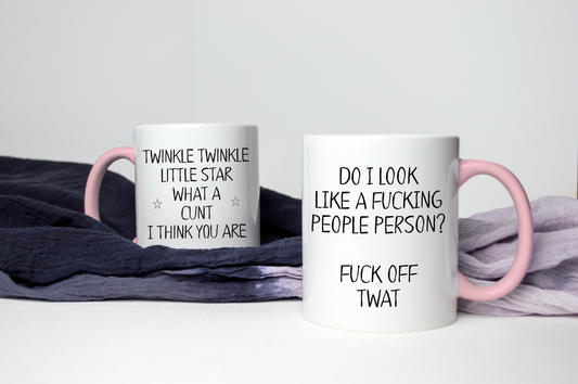 White mugs with pink handles and rims with the quote do i look like a fucking people person? fuck off, twat on the left, and twinkle twinkle little star what a c*nt i think you are on the right one. Printed in black ink.