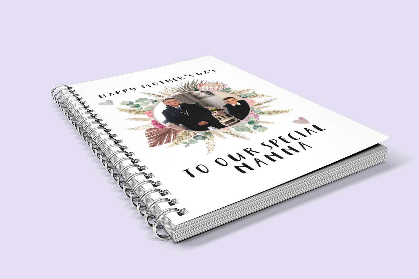 A white notebook which has a colourful floral design wreath with a personalised photo of 2 children in the middle. To the top of the flower is the words 'happy mother's day.' and to the bottom 'to our special nanna' Printed in black ink.