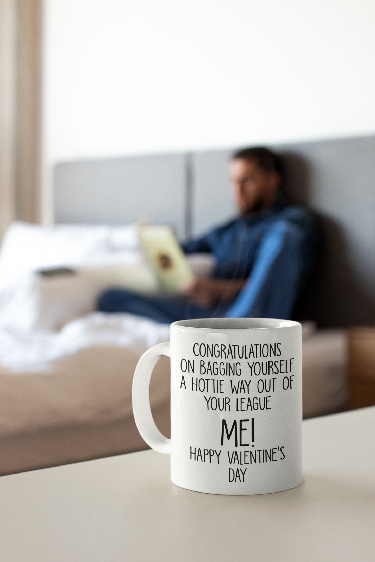 A white mug with the funny quote 'congratulations on bagging yourself a hottie way out of your league... Me!' Printed in black ink.
