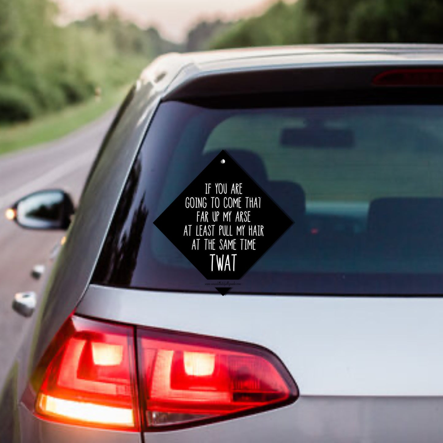 Black car window sign with the quote ' if you're going to come that far up my arse at least pull my hair at the same time, twat'. Also acts as a car freshener, add your own scent. 