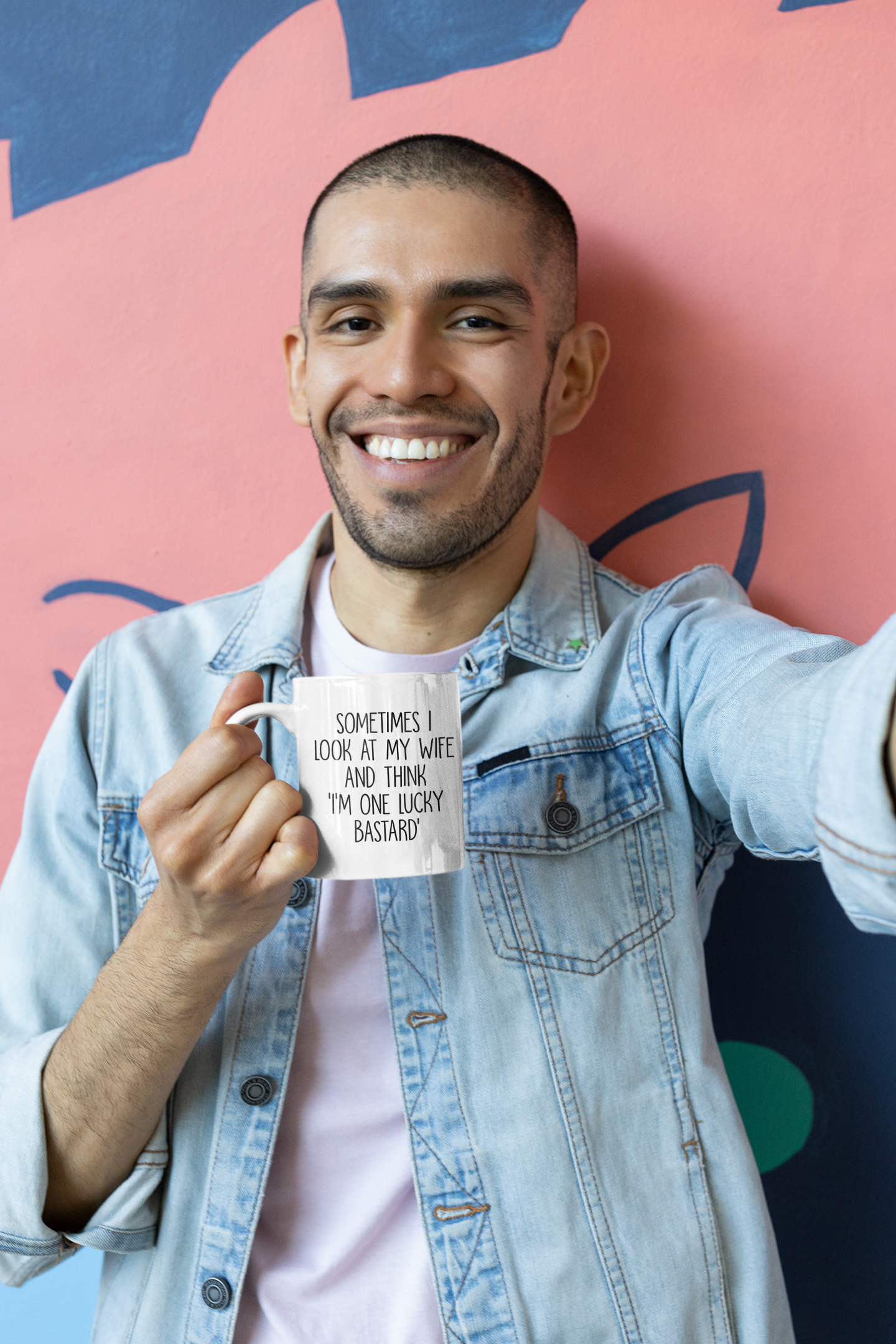 Man holding a white mug with a funny quote 'sometimes i look at my wife and think i'm one lucky bastard''. Printed in black ink.