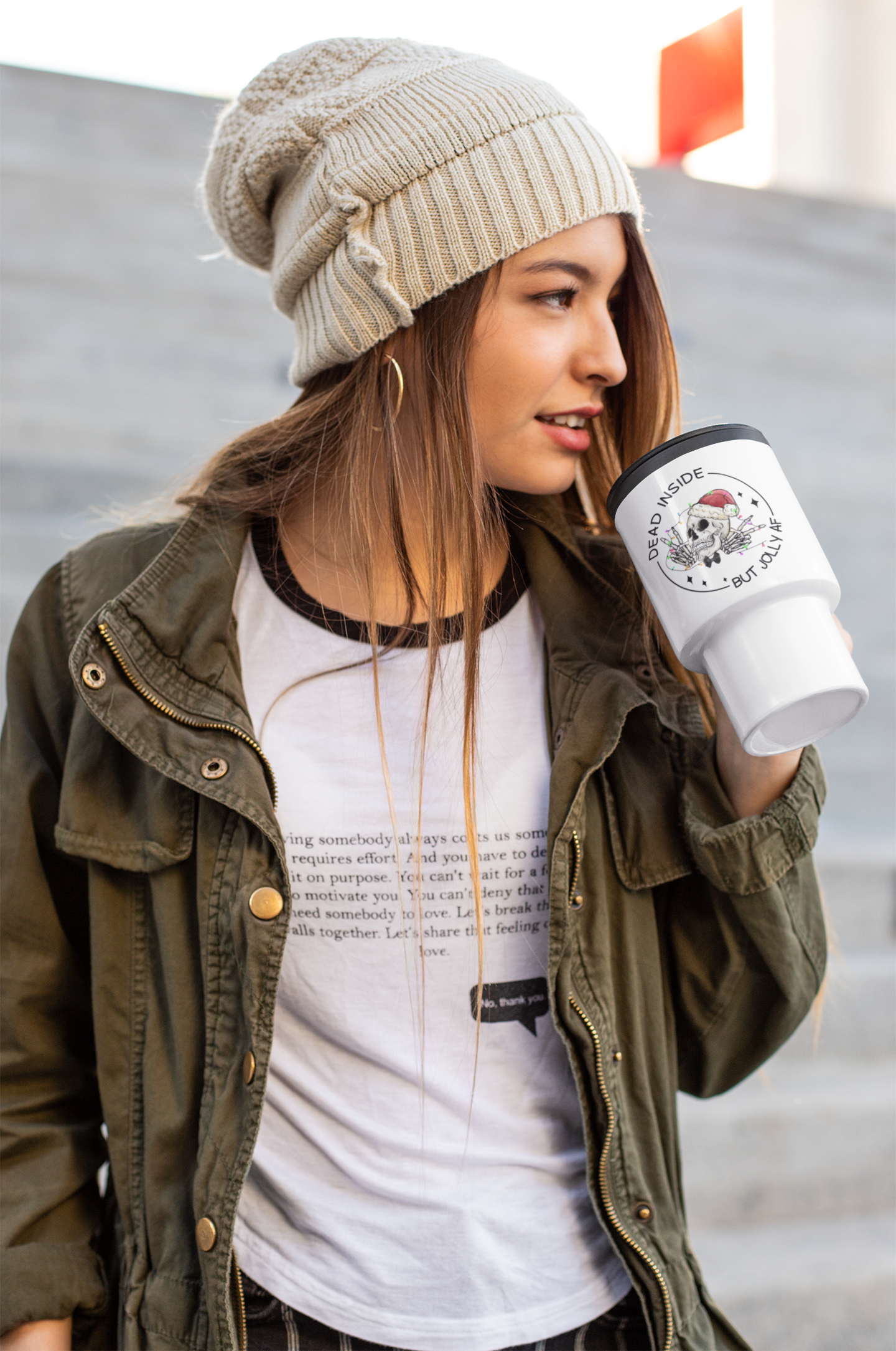 White travel mug with a black handle & black lid featuring a fun christmas skull design with the words dead inside but jolly as fuck. Printed in black ink.