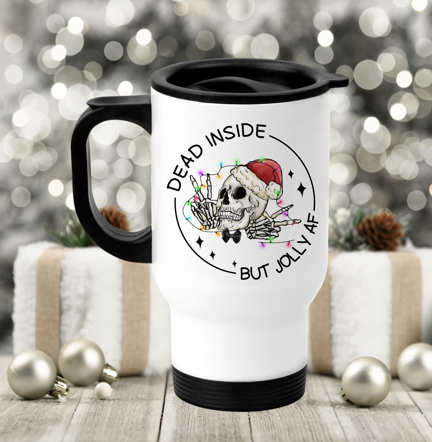 White travel mug with a black handle & black lid featuring a fun christmas skull design with the words dead inside but jolly as fuck. Printed in black ink.