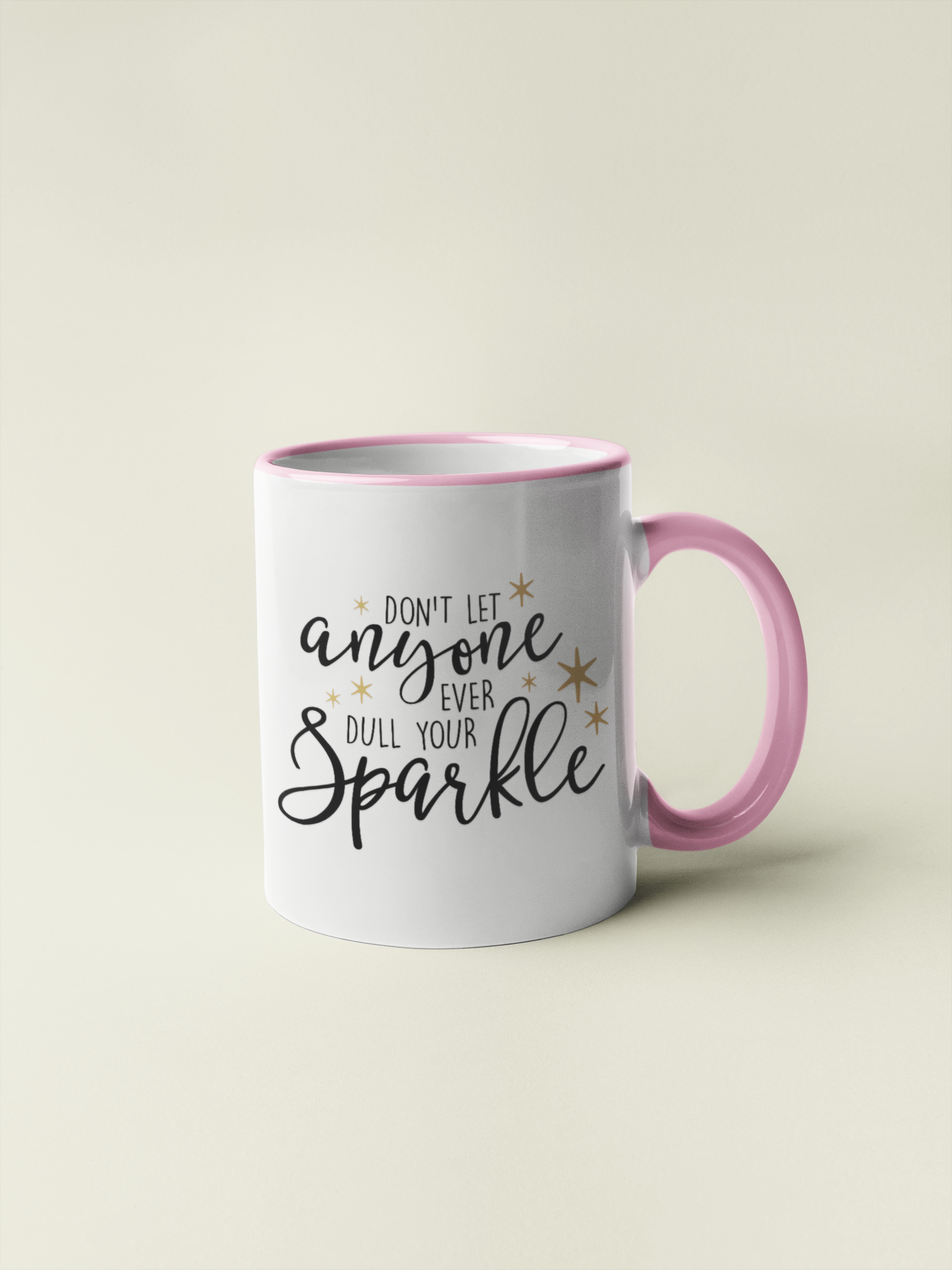 White mug with a pink handle & inner with the quote don't let anyone ever dull your sparkle, in a fancy font & surrounded by gold stars.