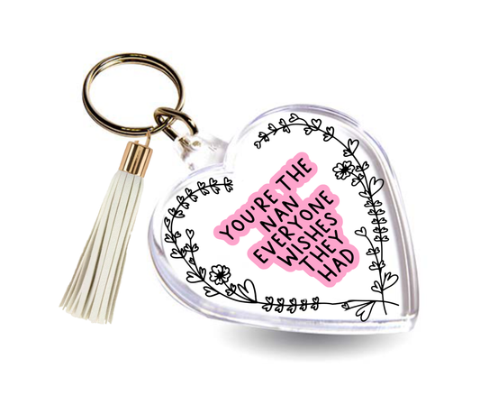 Acrylic heart shape keyring with a floral design around the edge. In the middle is a quote which reads 'you're the nan everyone wishes they had' printed in black with a pink outline. It also comes complete with a coloured tassel.