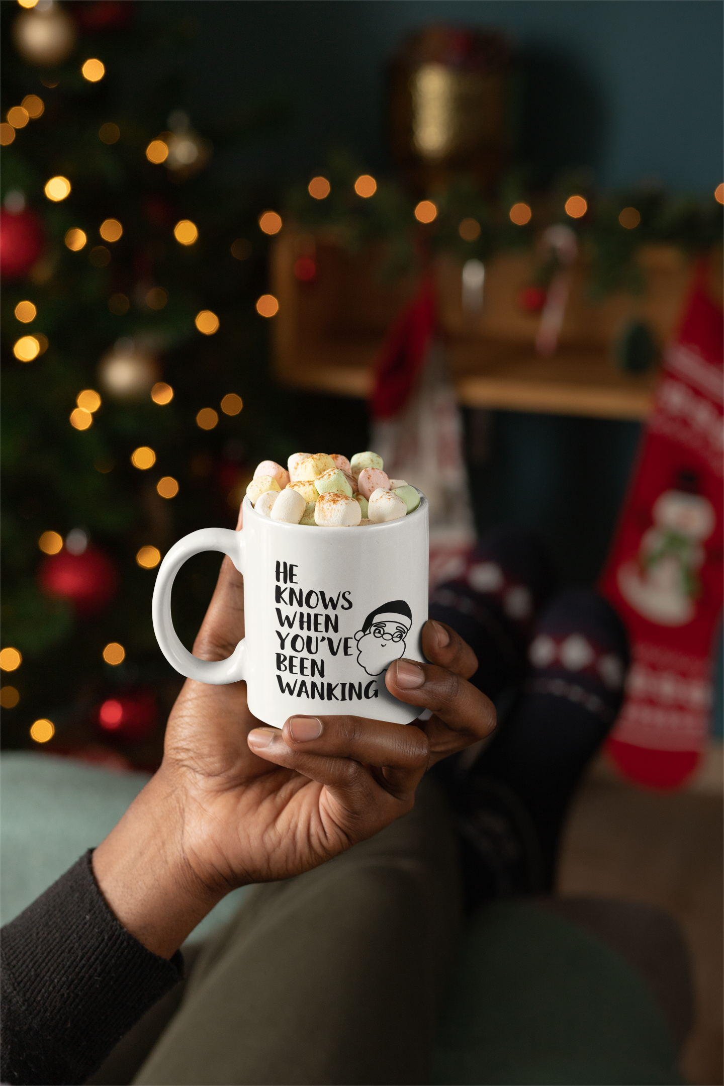 White mug with a cartoon santa head with the words 'he knows when you've been wanking' printed to the left side.