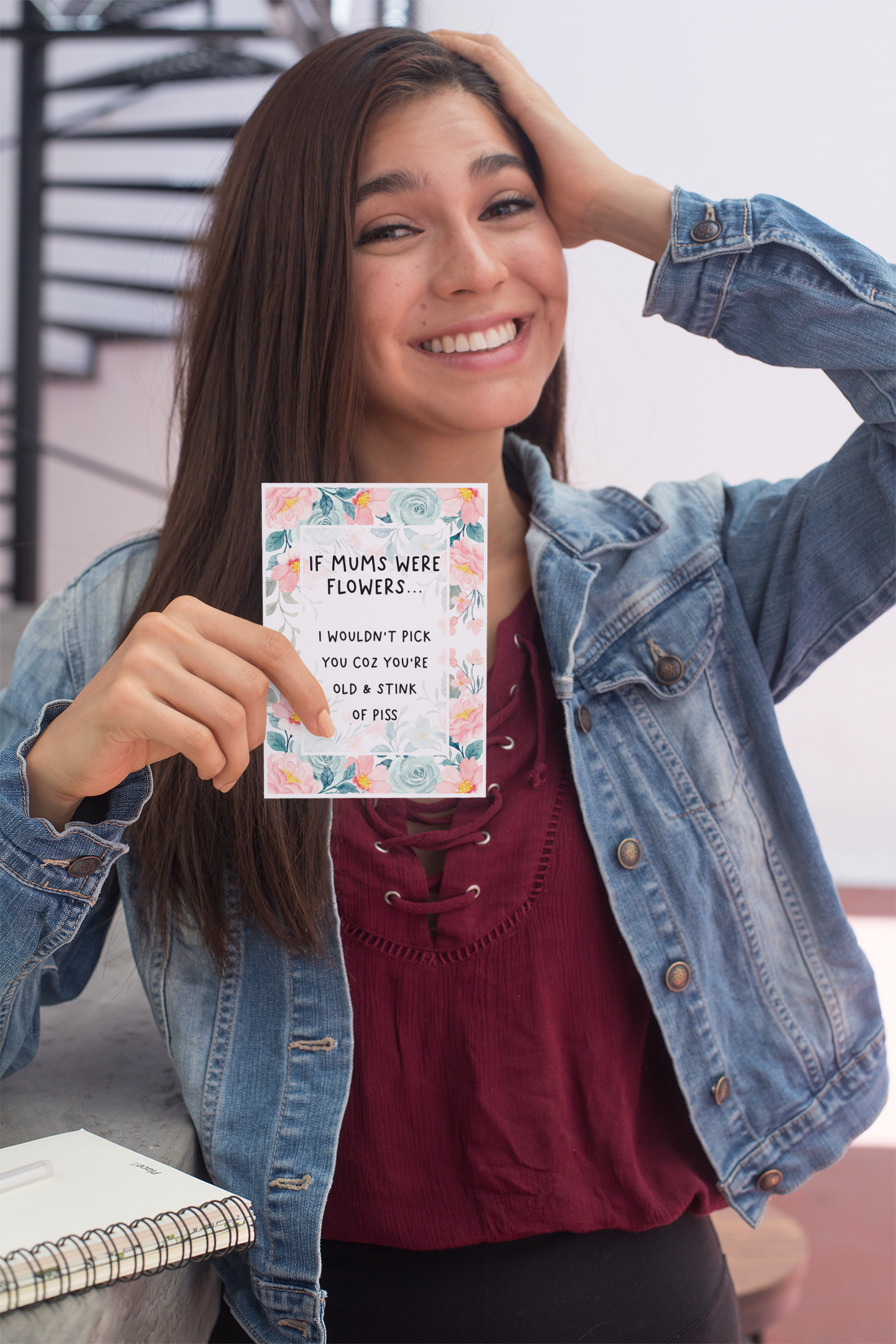Greetings card with a pastel colour floral design to the front with the quote 'if mums were flowers... i wouldn't pick you coz you're old & stink of piss' printed in the middle in black ink.