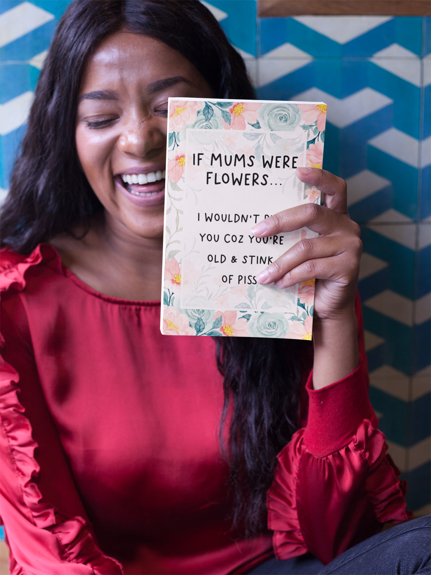 Greetings card with a pastel colour floral design to the front with the quote 'if mums were flowers... i wouldn't pick you coz you're old & stink of piss' printed in the middle in black ink.