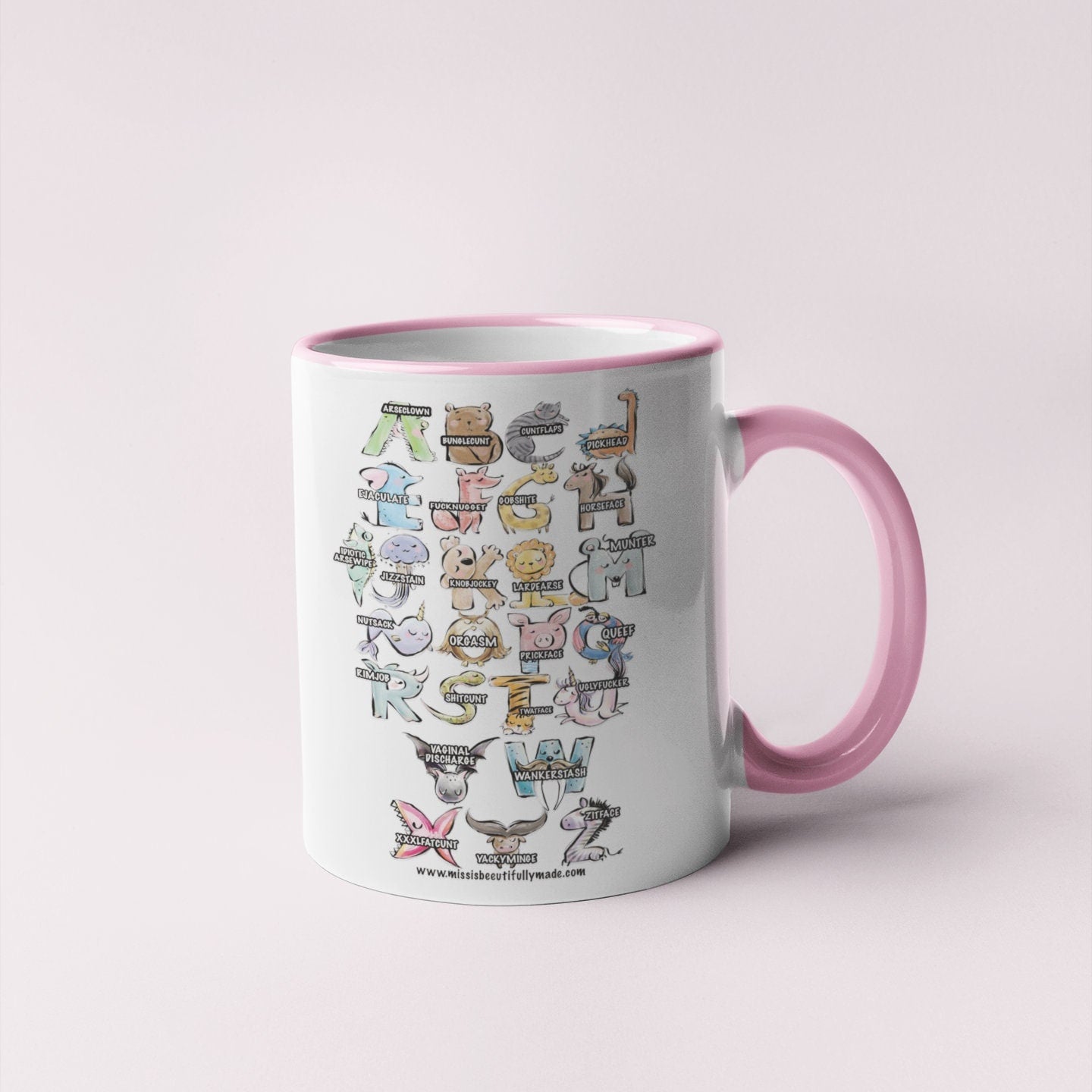 A white ceramic mug with a pink handle, featuring a fun, colourful, animal alphabet. A is for arseclown, B is for bunglec*nt etc.