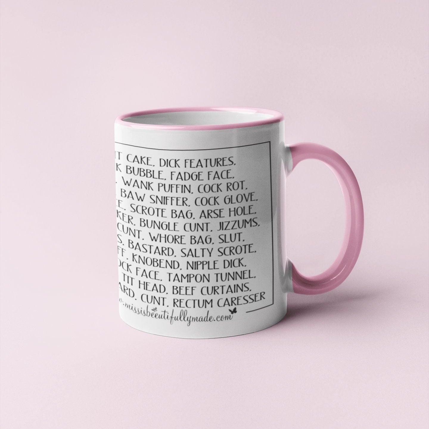 A white ceramic mug with a pink handle and inner featuring a full wrap design with funny words printed throughout. The words include c*nt chops, twat waffle, cock womble, piss flaps, etc. Printed in black ink.