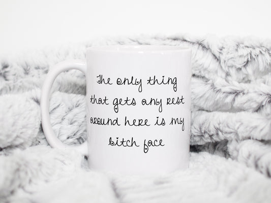 A white ceramic mug featuring the funny quote ‘ The only thing that gets any rest around here is my bitch face’. Printed in black ink.