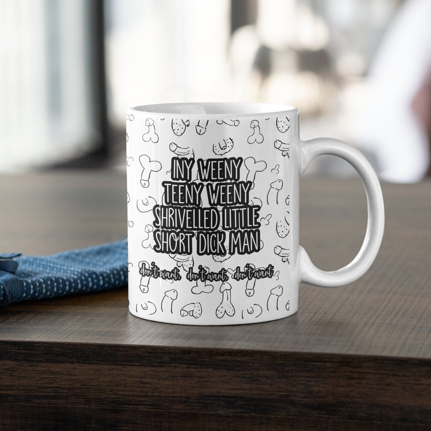 White mug with a funny willy design printed throughout. Over the print it reads iny weeny teeny weeny shrivelled little short dick man.. don't want, don't want, don't want.