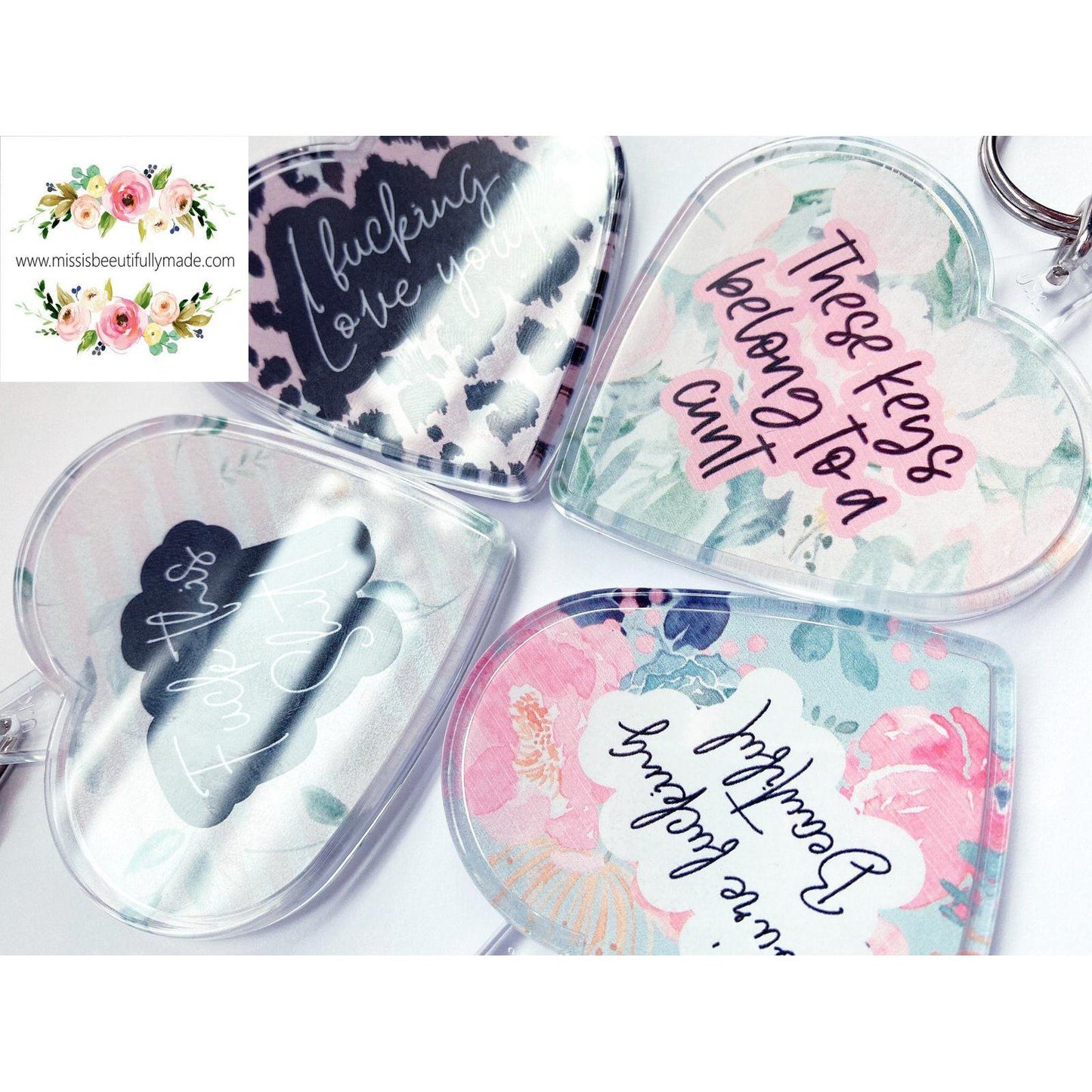 4 acrylic heart keyrings with various designs. Some examples of the quotes are 'fuck this shit', i fucking love you' and 'you're fucking beautiful'.