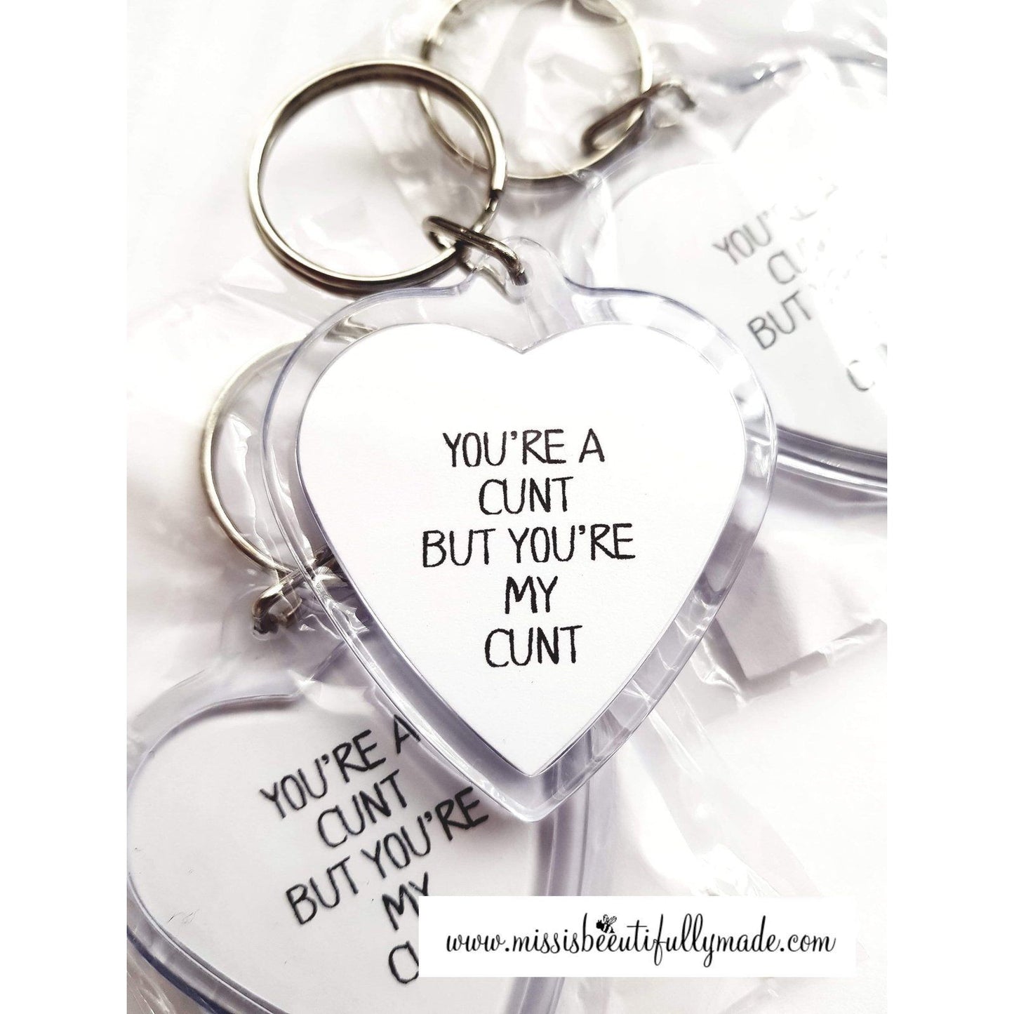 Acrylic heart keyring featuring the funny design 'you're a c*nt, but you'r my c*nt'.