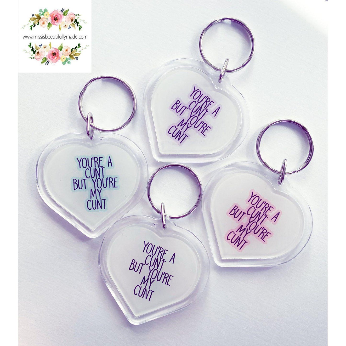 4 Acrylic heart keyrings featuring the funny design 'you're a c*nt, but you'r my c*nt', printed in blue, purple, pink & white.