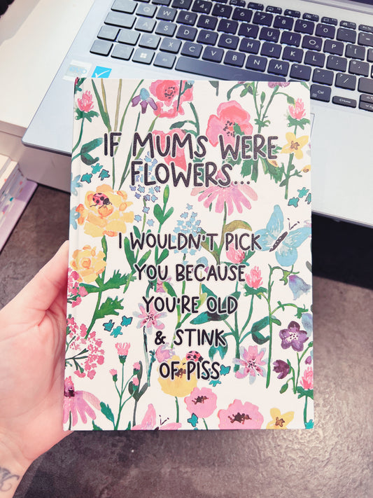 A5 notebook with a colourful floral design to the front and back. On the front in bold black lettering it reads ' if mums were flowers... i wouldn't pick you coz you're old & stink of piss'. 