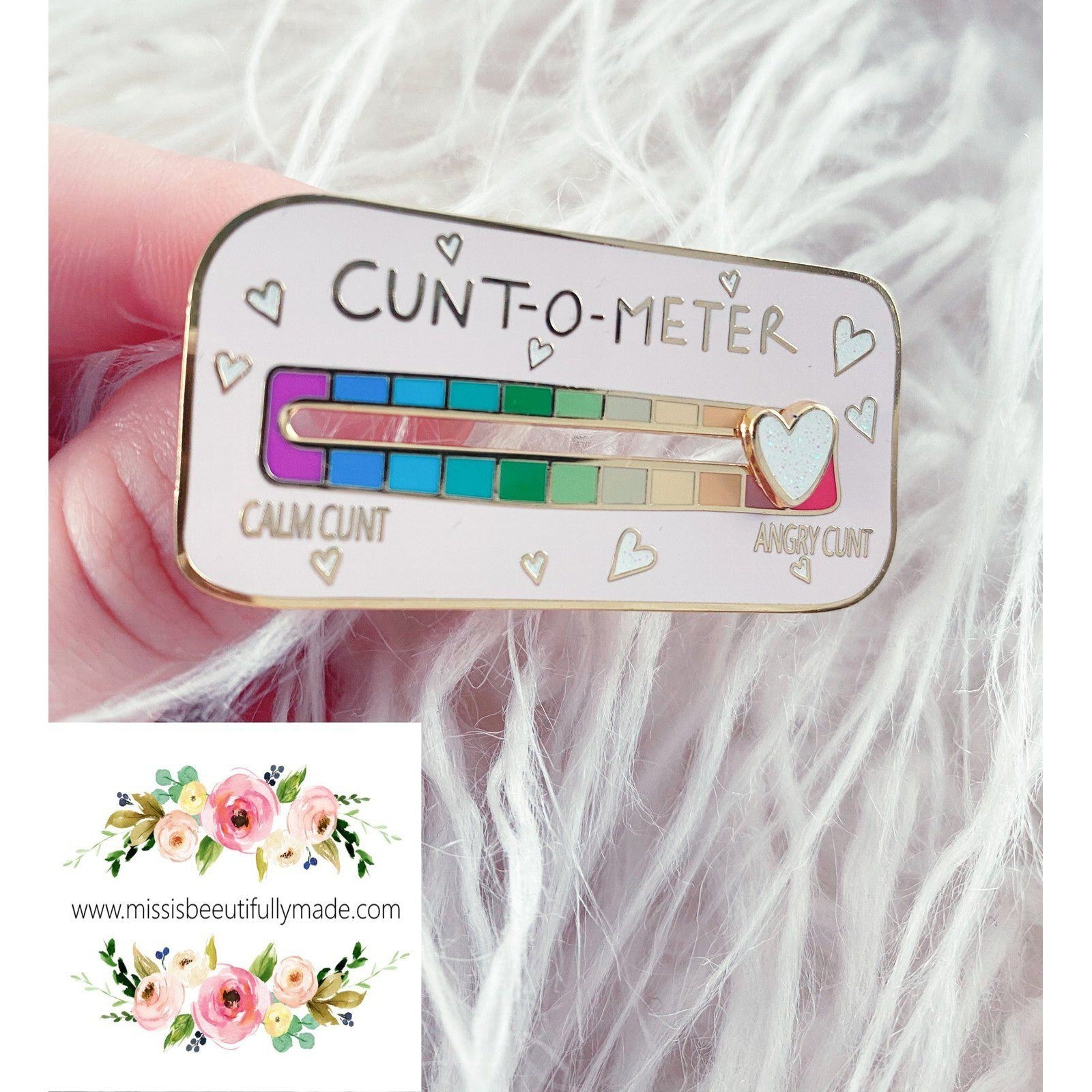 Gold enamel cunt-o-meter pin badge with a white glittery sliding heart. Slide from calm cunt to angry cunt with this funny interactive pin badge with pretty pastel rainbow colours.