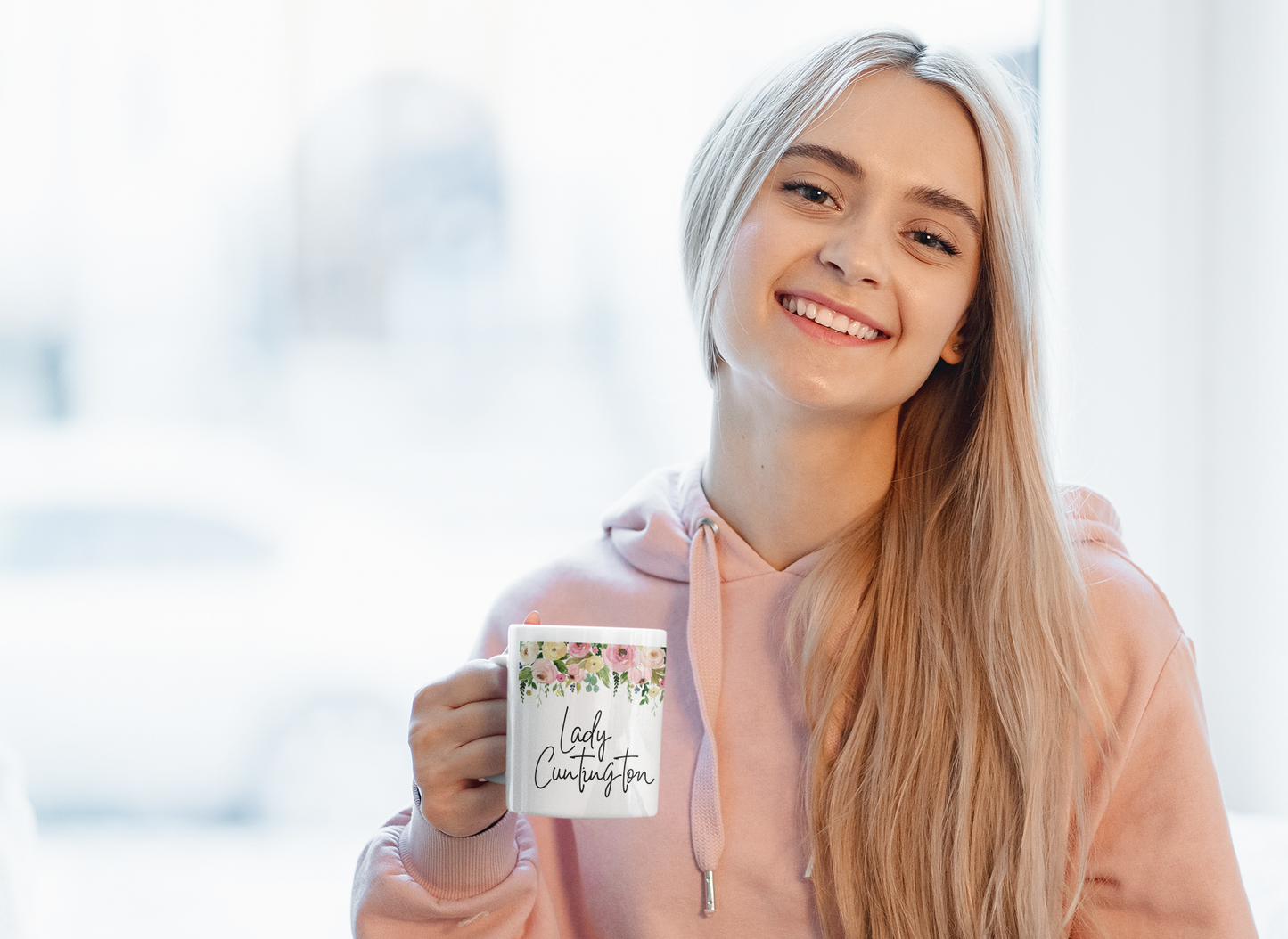 White mug with a colourful floral border to the top. Underneath is the quote lady cuntington in black ink.