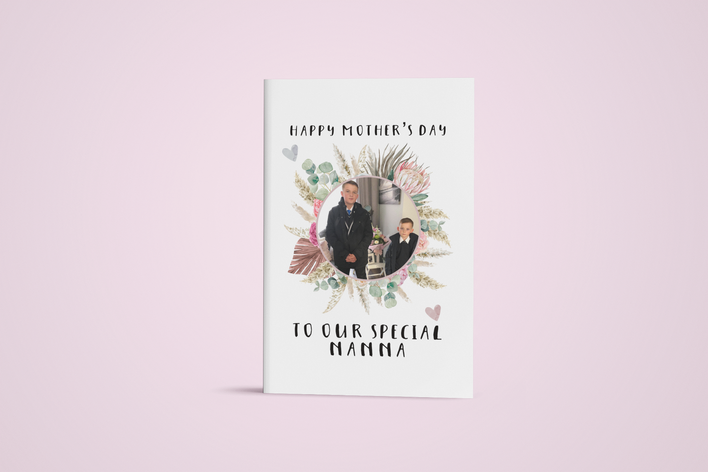 A white notebook which has a colourful floral design wreath with a personalised photo of 2 children in the middle. To the top of the flower is the words 'happy mother's day.' and to the bottom 'to our special nanna' Printed in black ink.
