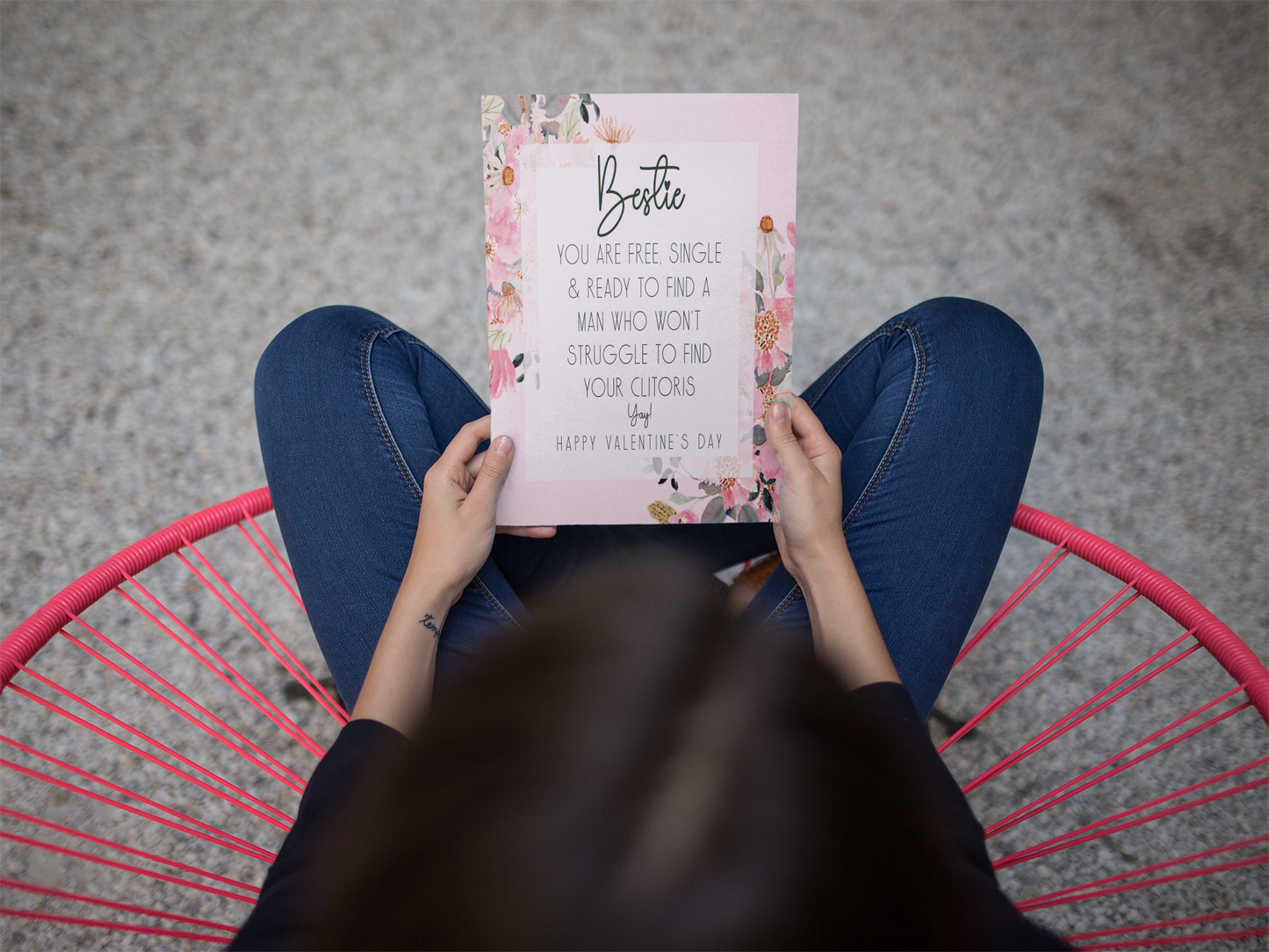 White card with a pink floral design to the front. In the middle has a funny message that reads 'bestie, you are single & ready to find a man who won't struggle to find your clitoris. Yay, happy valentine's day'. Printed in black ink.