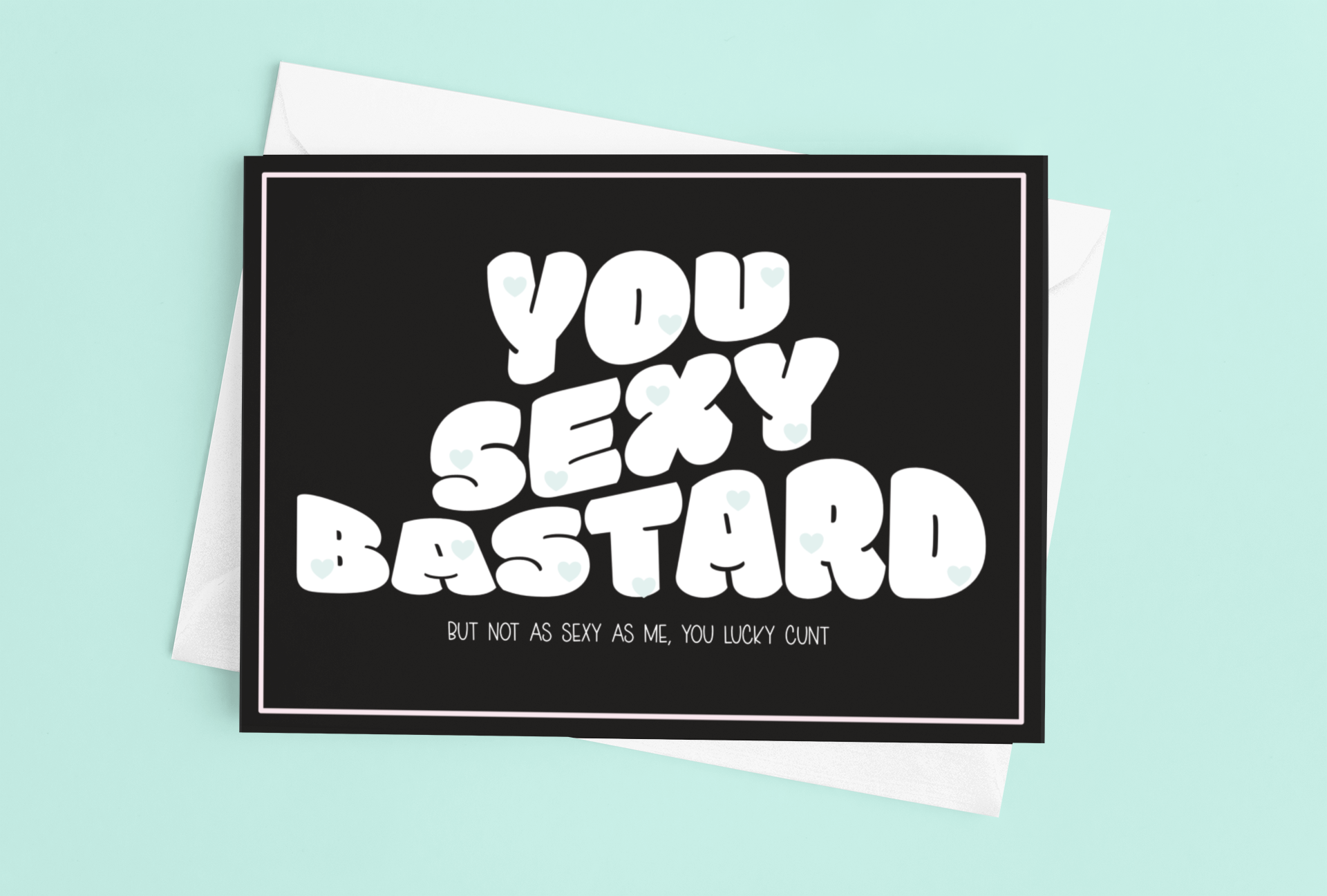 Black horizontal greetings card with a fun quote saying 'you sexy bastard' in a bold font. Underneath is a smaller font which reads 'but not as sexy as me, you lucky c*nt.