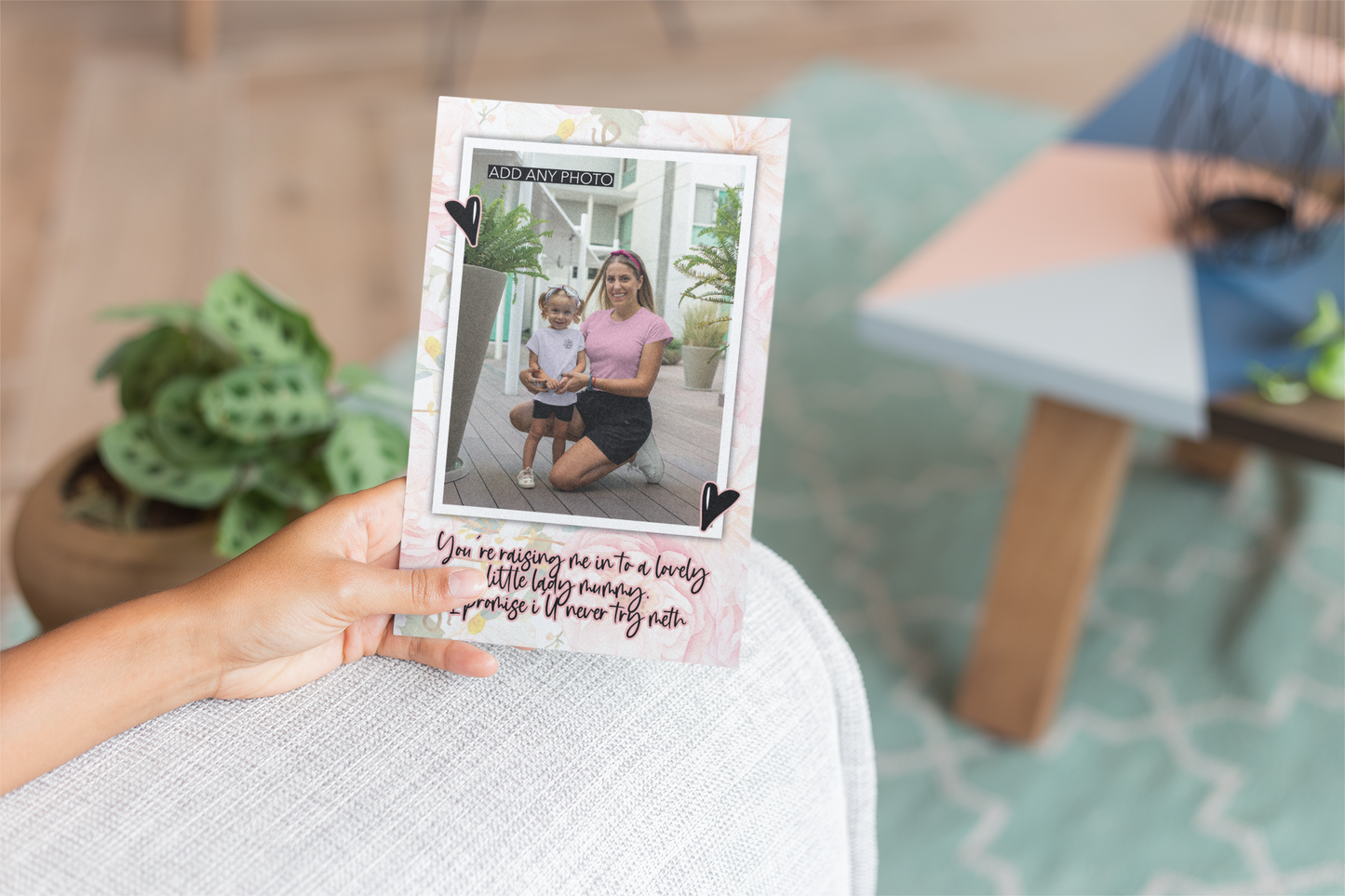 Floral greetings card with a personalised photo inside a white frame, situated to the front. Two black hearts for decoration around the frame and a quote underneath which reads 'you're raising me in to a lovely little lady, mummy. I promise i'll never try meth'. Printed in black ink with a rose colour outline.