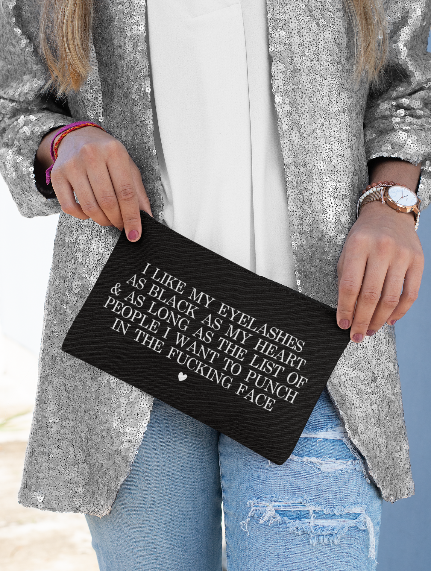 Black cosmetic bag featuring a funny quote in a bold text which reads 'i like my eyelashes as black as my heart & as long as the list of people i want to punch in the fucking face.' Printed in white.