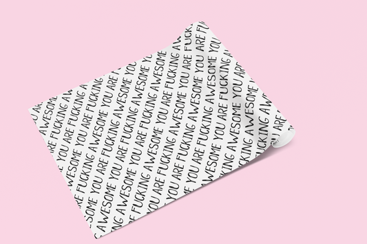 A roll of gift wrap laid out on to a pink surface. Features a funny repetitive quote 'you are fucking awesome' in black ink.