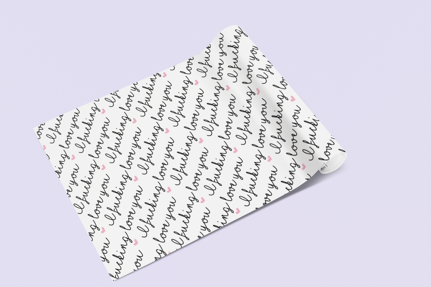 A roll of gift wrap laid out on to a lilac surface. Features a funny repetitive quote 'i fucking love you'. Printed in black ink with little pink hearts.