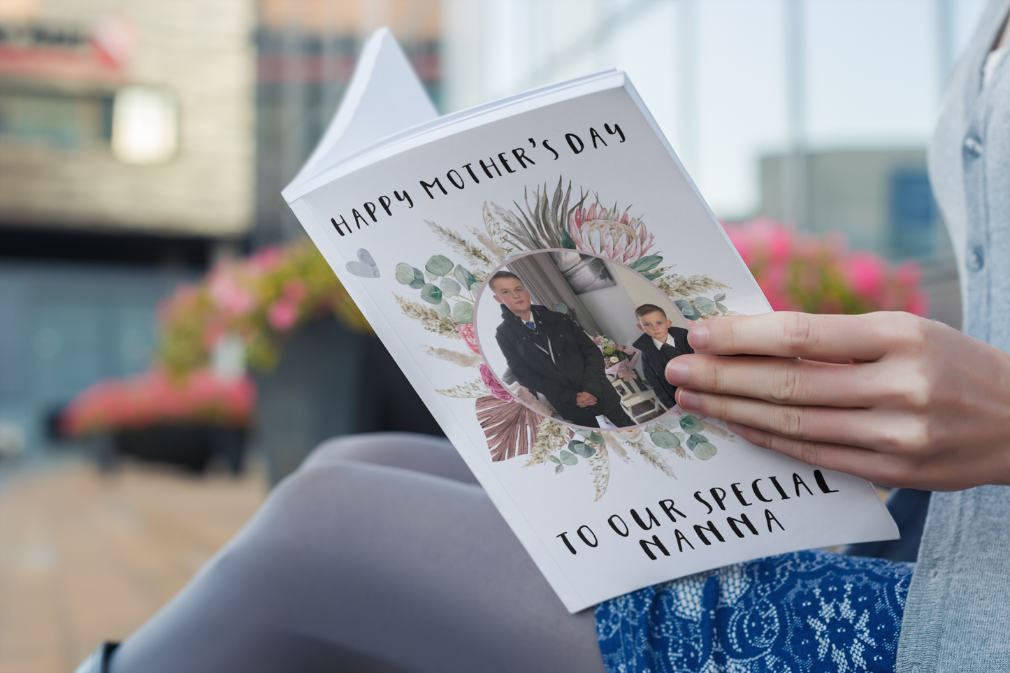 A white notebook which has a colourful floral design wreath with a personalised photo of 2 children in the middle. To the top of the flower is the words 'happy mother's day.' and to the bottom 'to our special nanna' Printed in black ink.