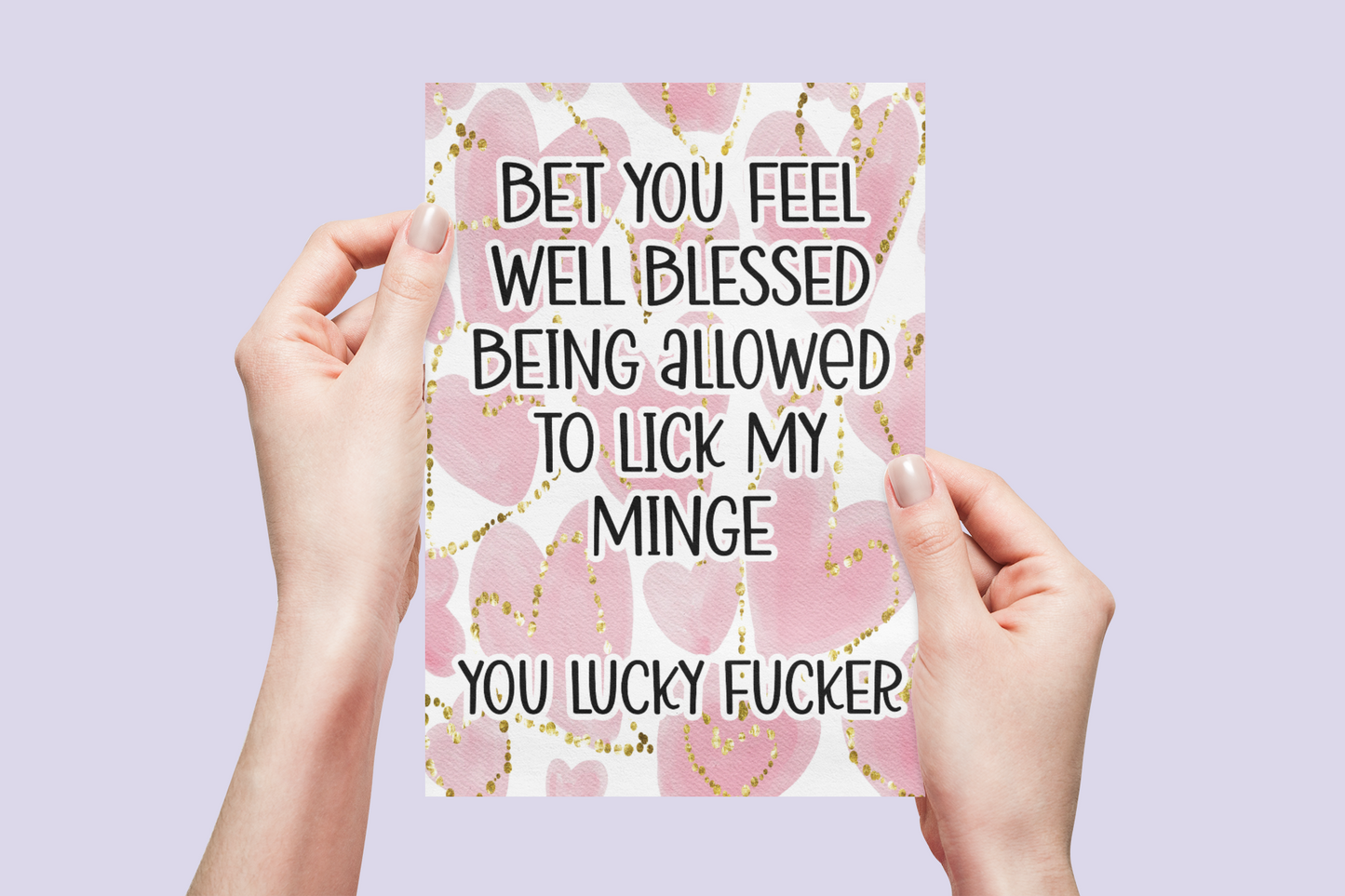 White vertical greetings card with a pink watercolour heart design to the front. Over the design is a funny quote 'bet you feel well blessed being allowed to lick my minge.. you lucky fucker'. Printed in back ink.