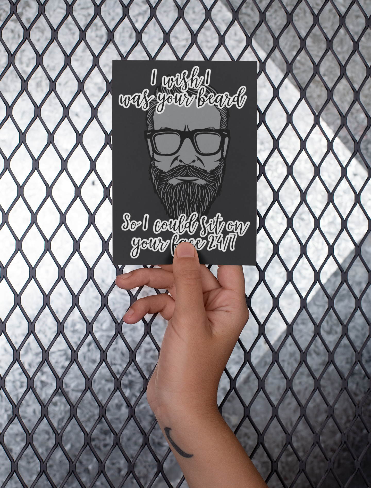 Hand holding a black vertical card featuring a clipart of a beard. To the top is the quote 'i wish i was your beard' and to the bottom ' so i could sit on your face 24/7. Printed in white.