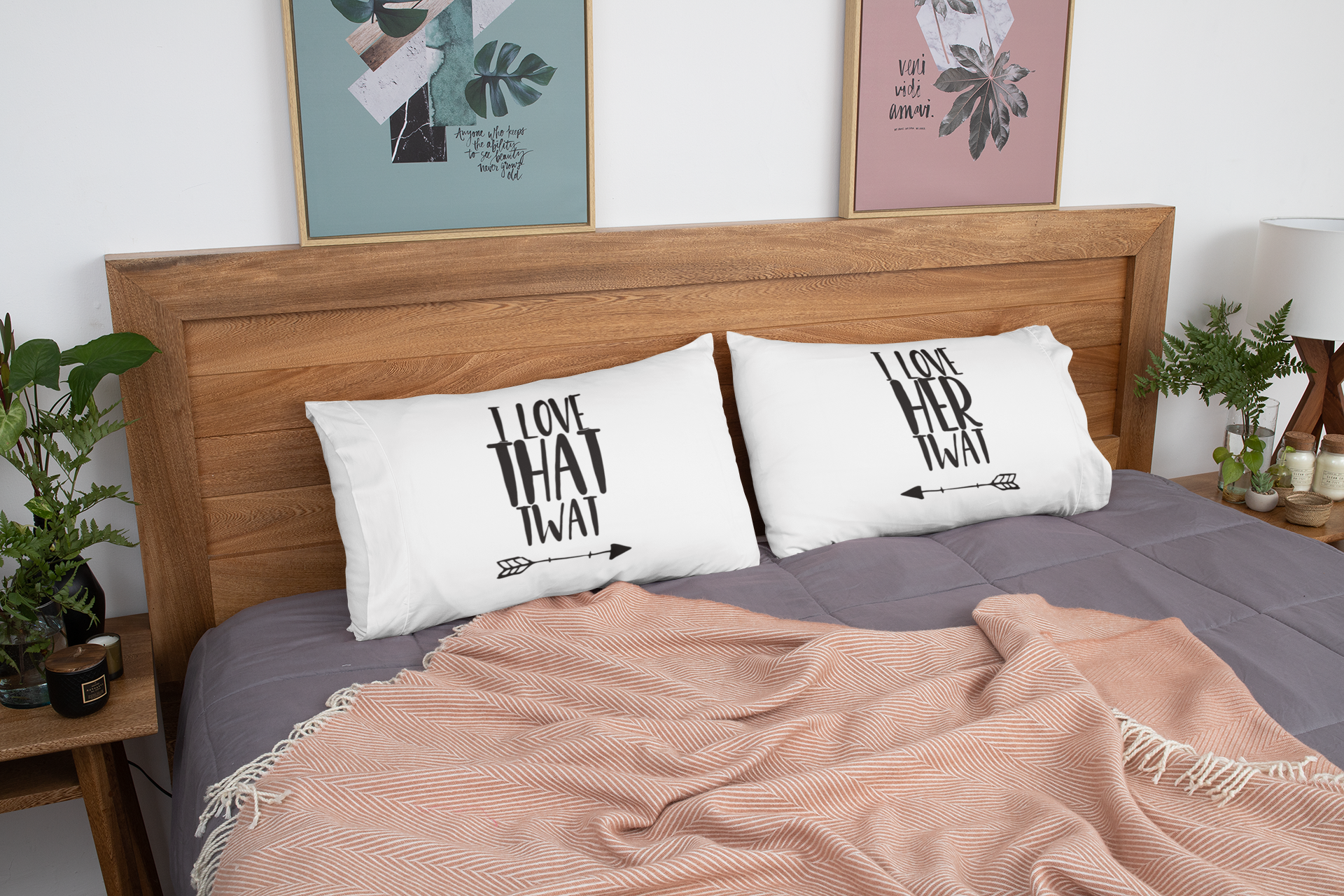 White pair of pillow cases on a made up bed, featuring funny quotes. The left reads 'i love that twat' with an arrow pointing to the right. The other pillow reads 'i love her twat' with an arrow pointing to the left.