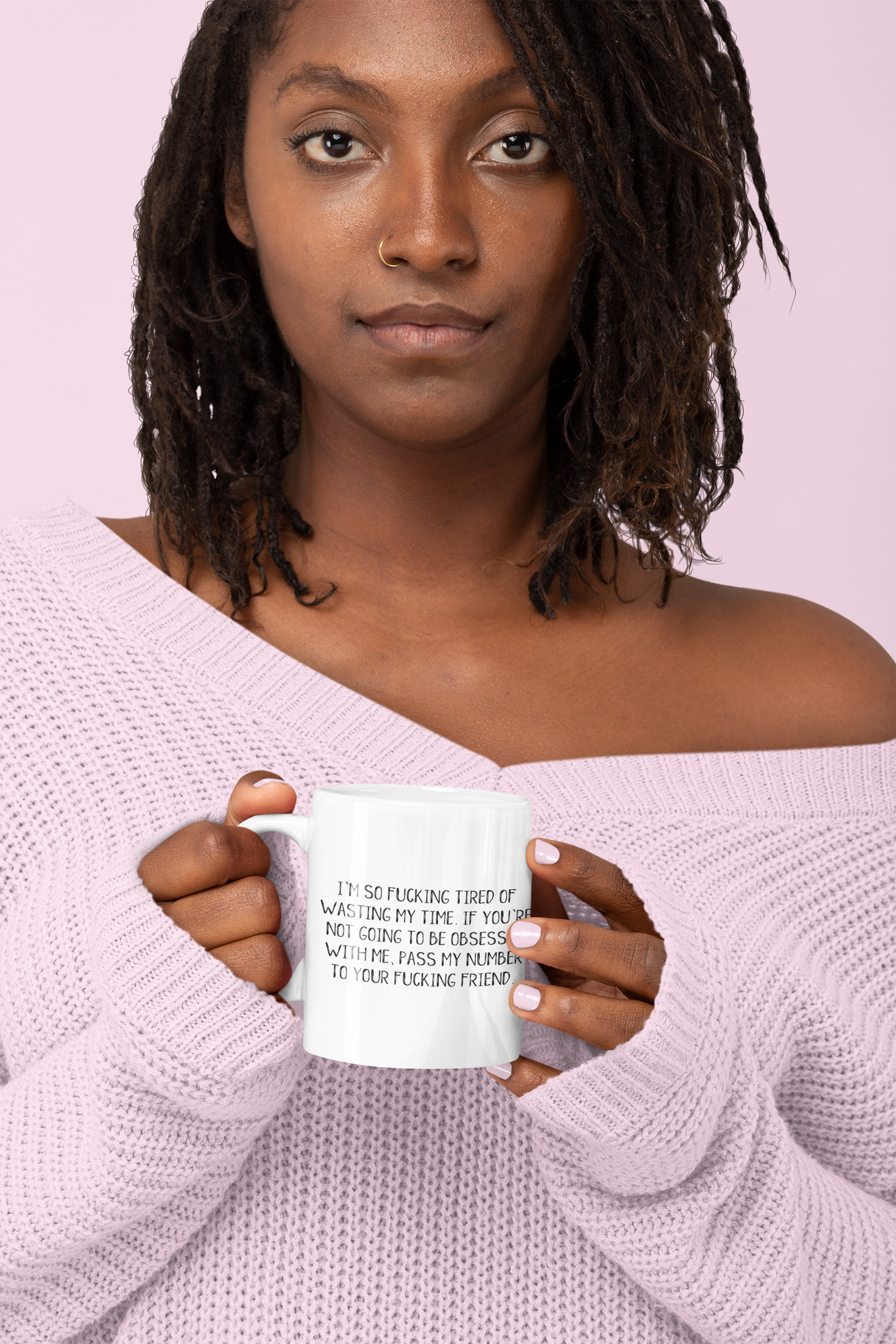 Woman holding a white ceramic mug featuring the funny quote 'i'm so fucking tired of wasting my time. If you're not going to be obsessed with me, pass my number to your friend'. Printed in black ink.