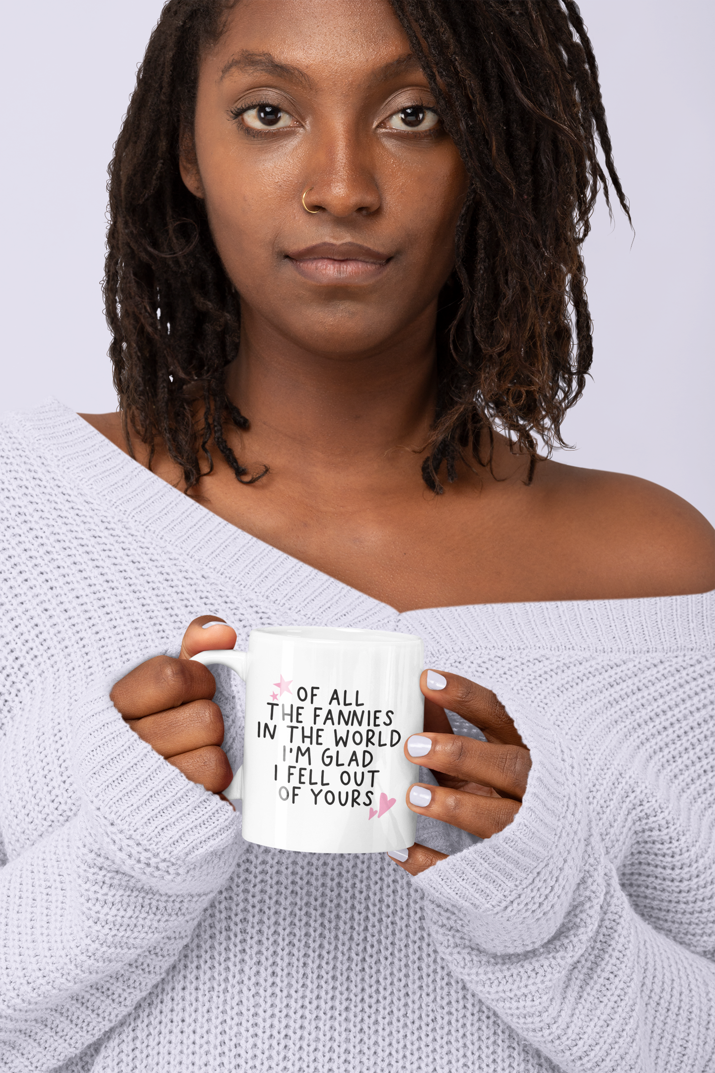 White ceramic mug with a funny quote 'of all the fannies in the world i'm glad i fell out of yours' in black ink. To the top left & bottom right of the text are little pink hearts and stars.