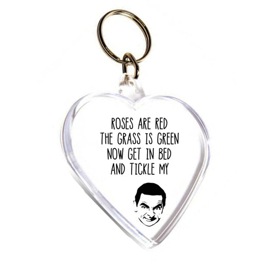 Acrylic heart shape key ring featuring a silhouette of Mr Bean. To the top it reads 'roses are red, the grass is green, get in bed & tickle my...'. Printed in black ink.